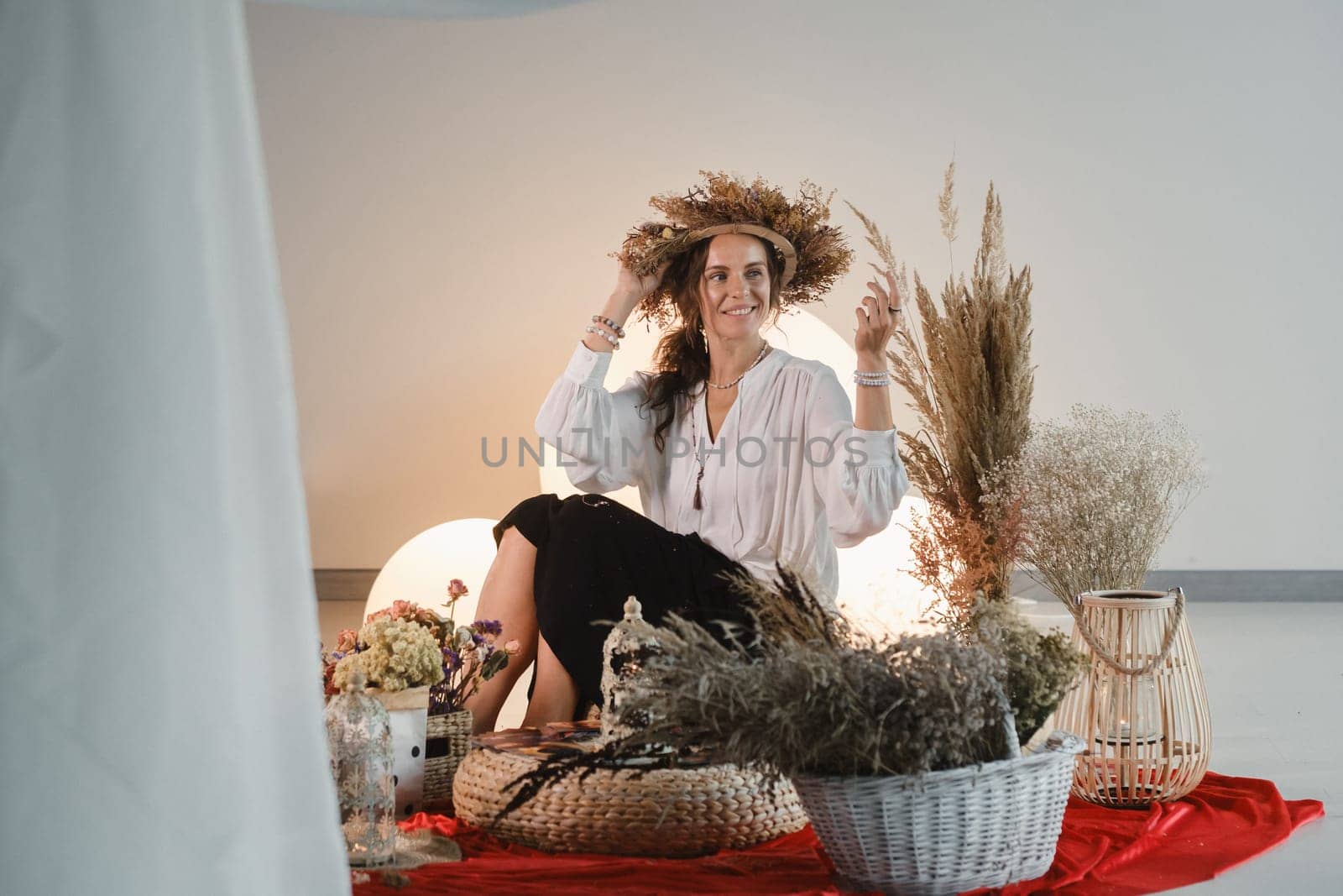 Women's circle and practice in the use of metaphorical cards. The girl is sitting surrounded by flowers.