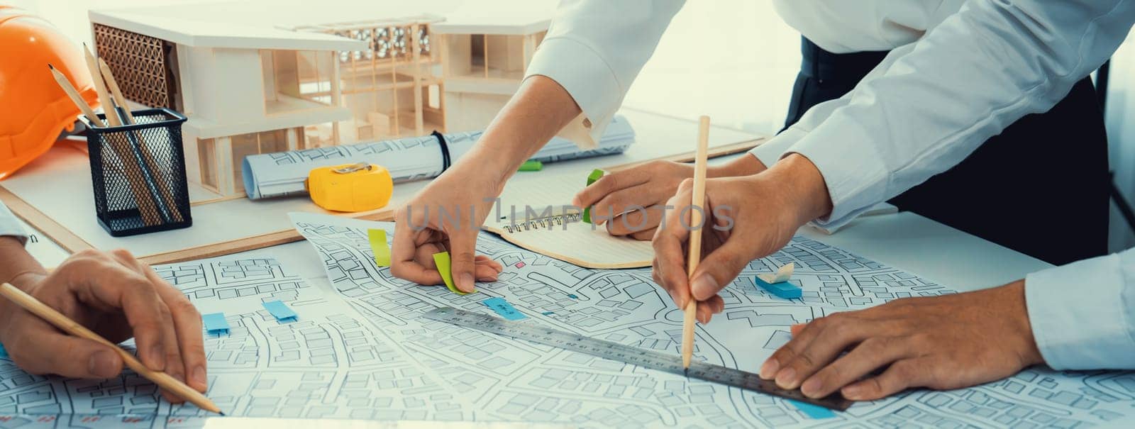 Worker, architect and engineer work on real estate construction project oratory planning with cartography and cadastral map of urban town area to guide to construction developer business plan of city