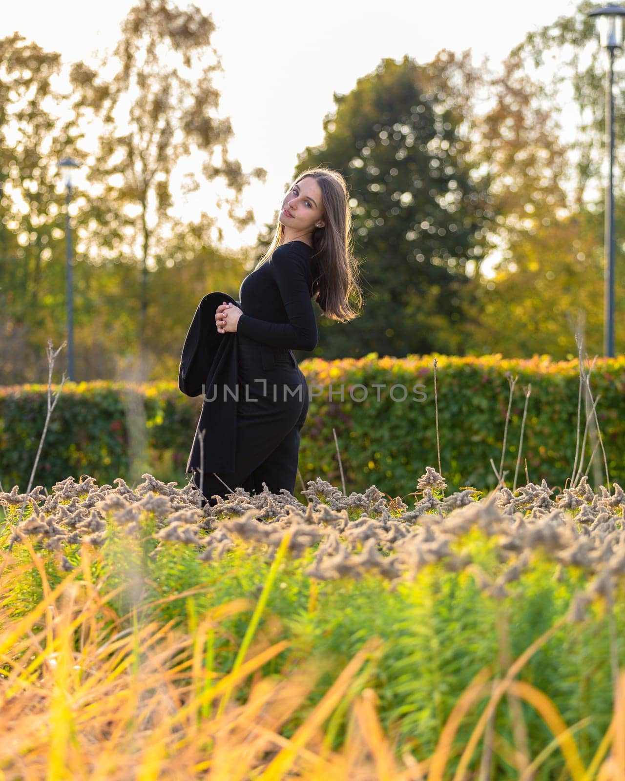 Beautiful girl posing in the sunshine in an autumn park