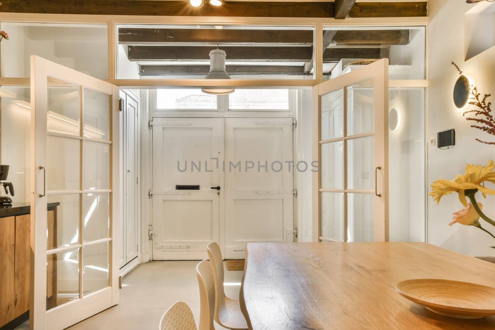 a dining room with white doors and a wooden table by casamedia