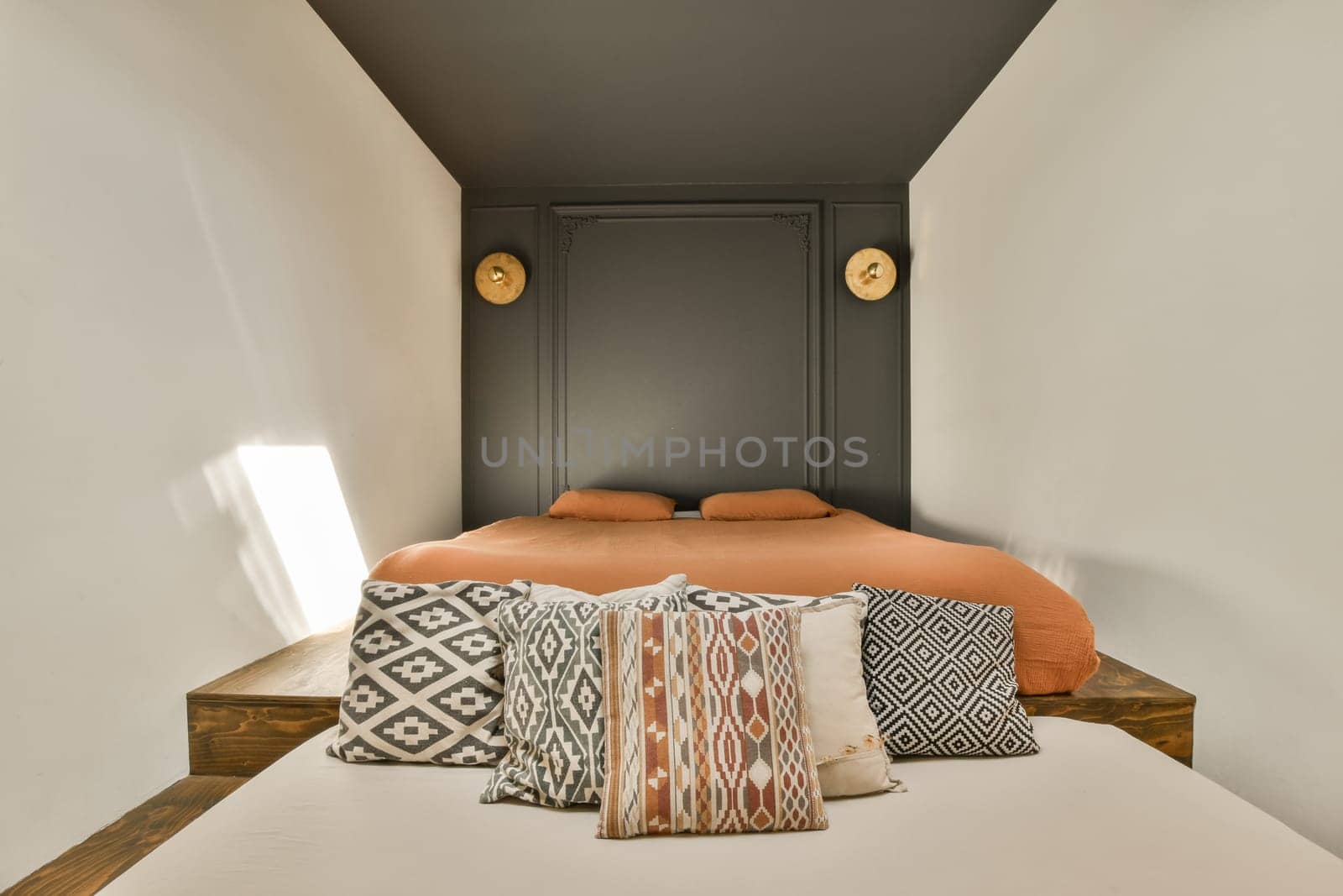 a bed in a room with white walls and black trim around the headboard, pillows and pillow on it