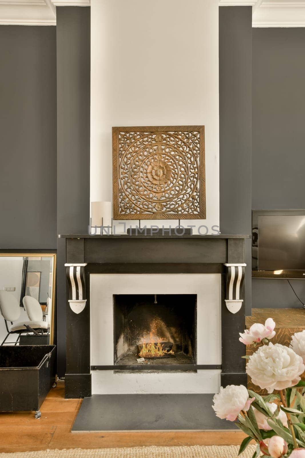 a living room with a fireplace and a flower arrangement by casamedia