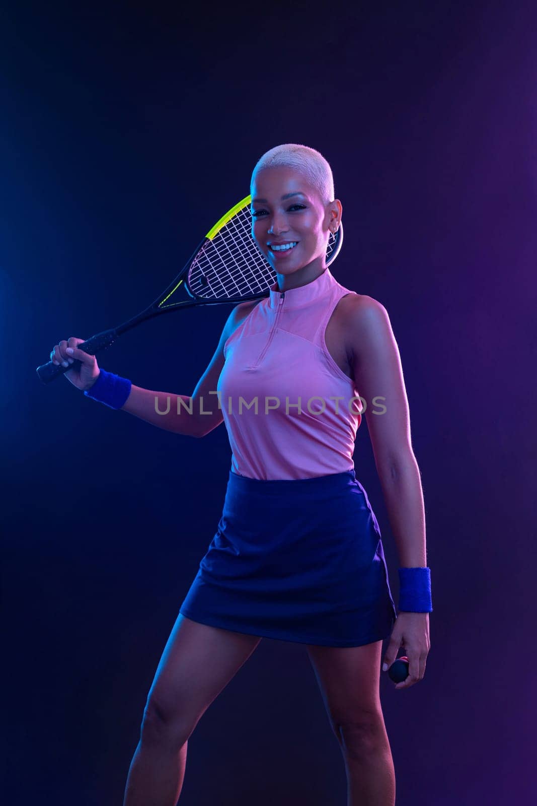 Squash player on a squash court with racket. White sportswear. Beautiful girl teenager and athlete with racket on court. Sport concept