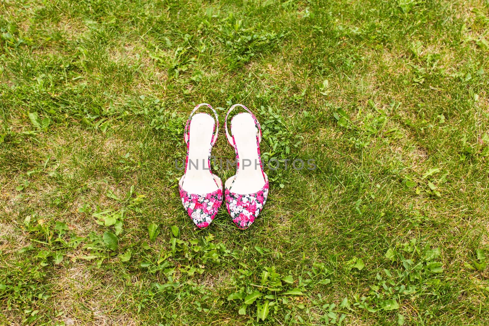 Shoes of a woman on green grass. Summer holiday concept, daylight.