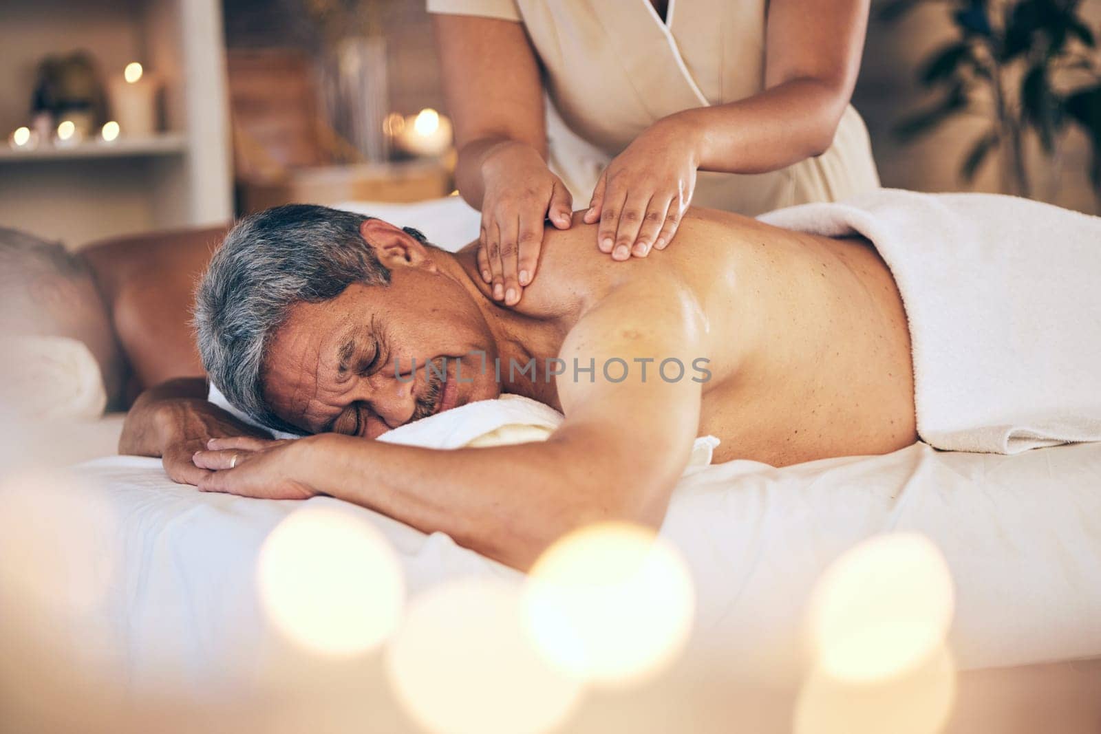 Senior man, sleeping and relax for back massage, spa treatment or body care in physical therapy at resort. Calm elderly male person relaxing or asleep on salon bed for zen, stress relief or getaway.