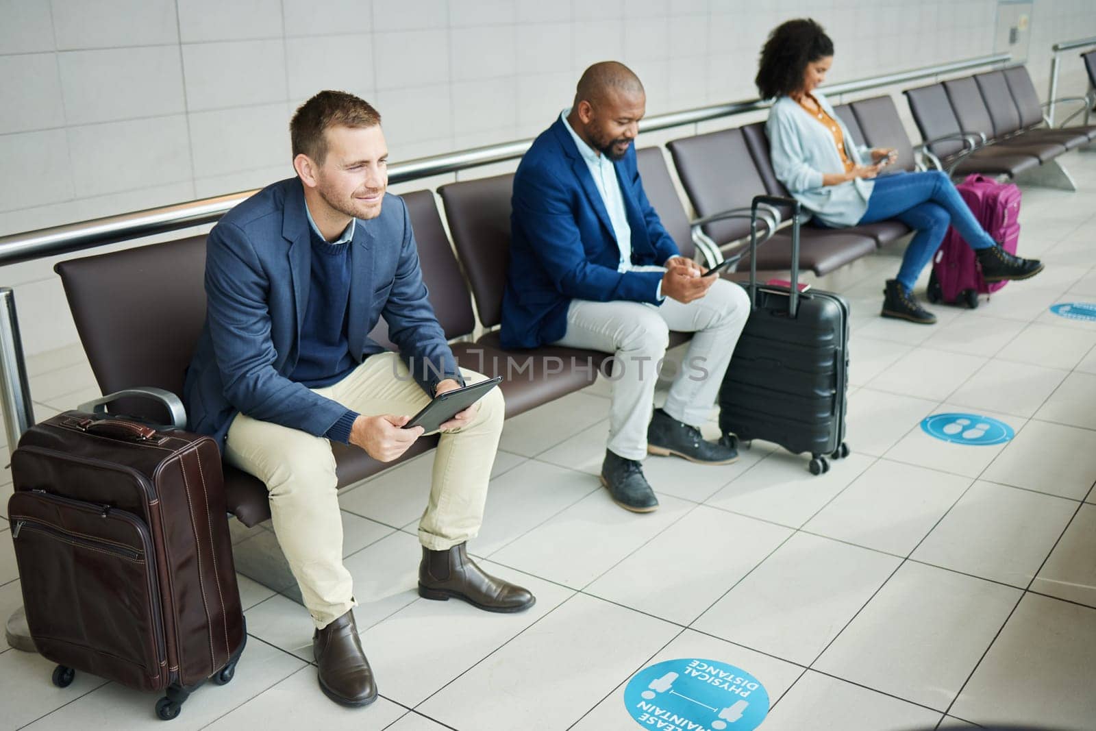 Traveling, tablet and man in airport, passport and luggage with tourist waiting, boarding or international. Male leader traveler or gentleman with suitcase, departure and ticket for travel and online by YuriArcurs
