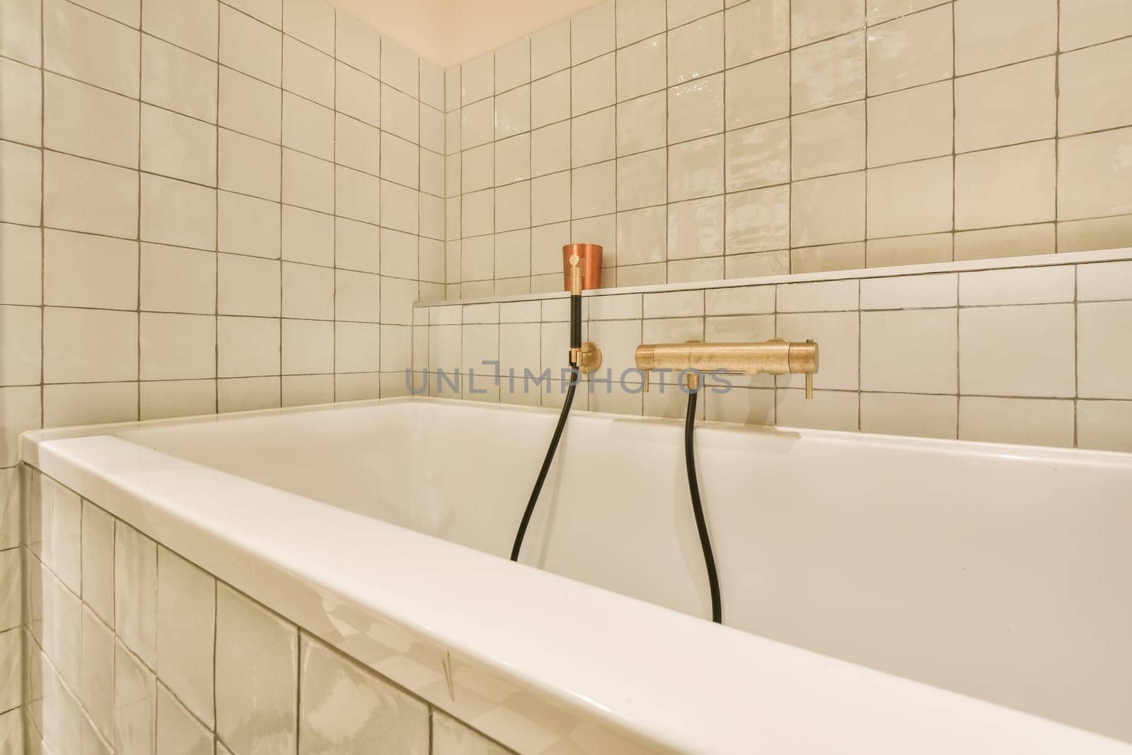 a white bath tub in a white tiled bathroom by casamedia