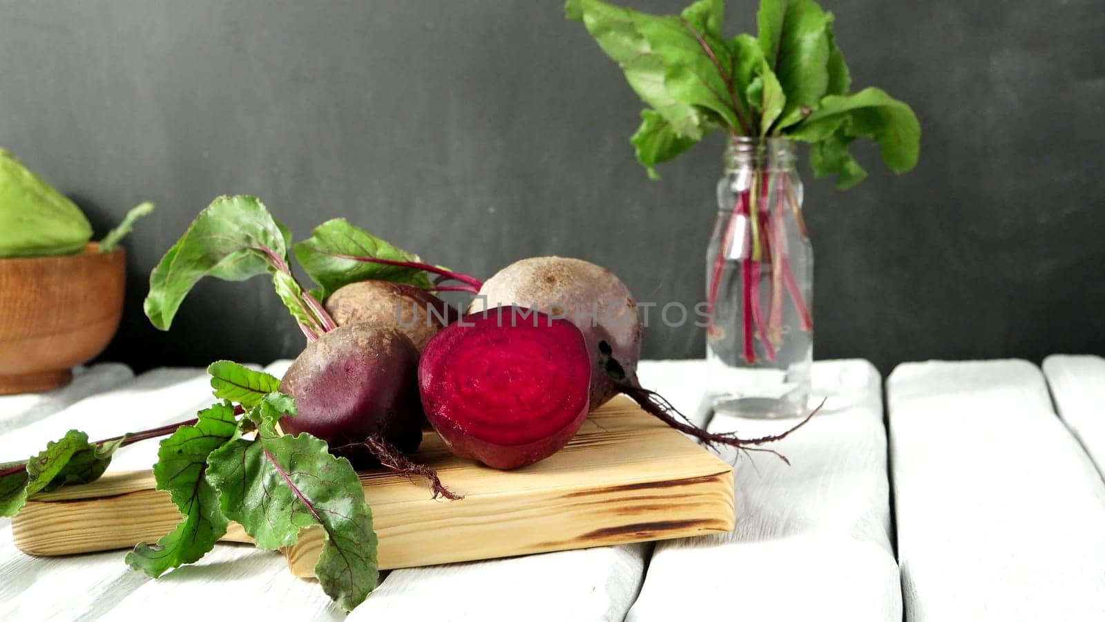Beetroots on white painted rustic wooden table with slate background.
