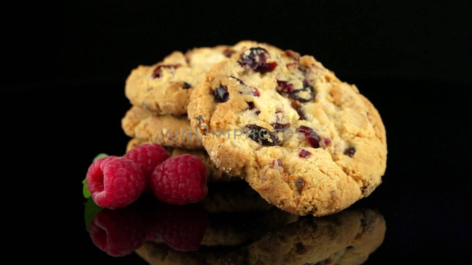 Dried fruits chip cookies and raspberries isolated on black background.
