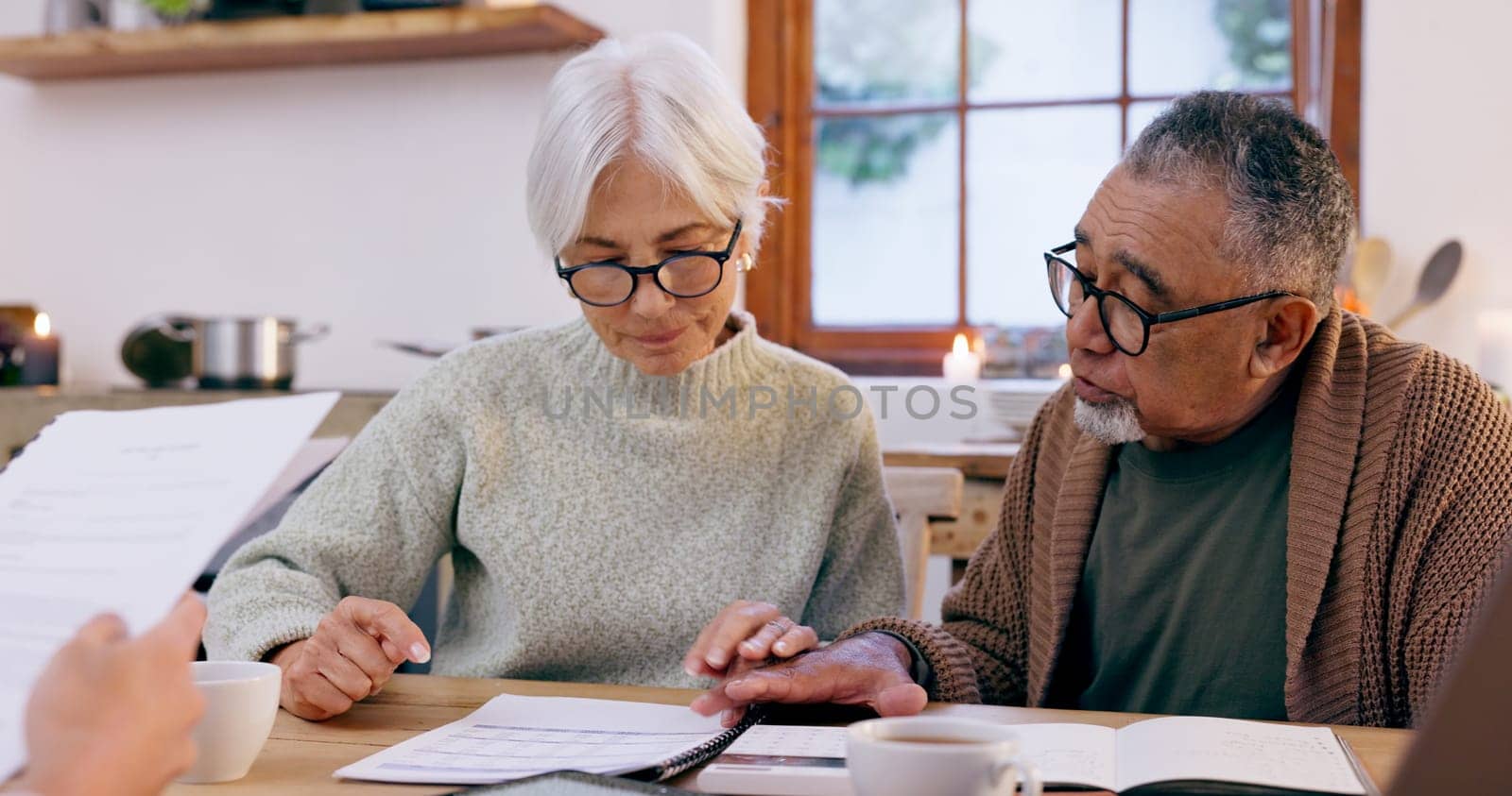Couple, paperwork and reading for insurance in retirement, planning and bills or documents. Senior people, marriage and communication or discussion for future, saving and finance in kitchen at home.