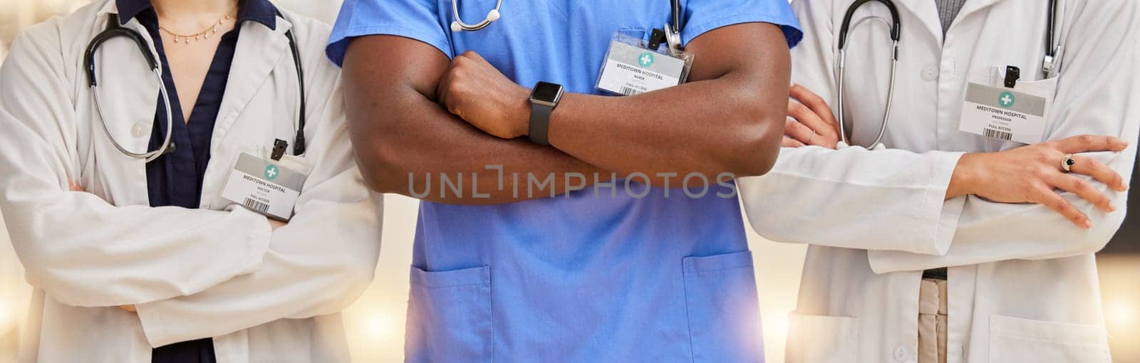 Doctors, healthcare and team with arms crossed in a hospital for teamwork and collaboration. Diversity, group and professional man and women with stethoscope and name tag for career in medicine.