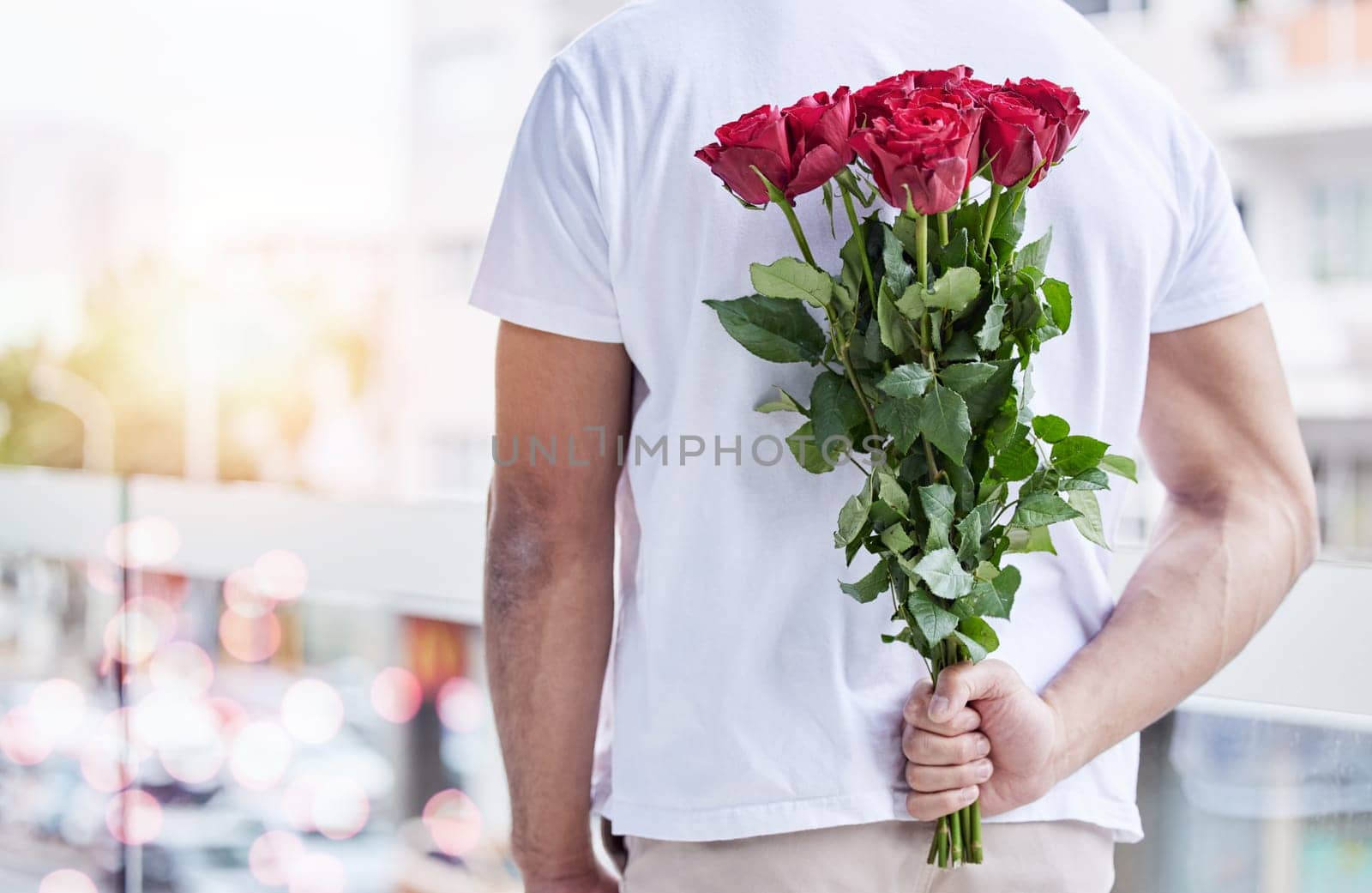 Love, surprise and man with roses behind back for date, romance and hope for valentines day. Romantic confession, floral gift and person with bouquet of flowers in city for proposal or engagement