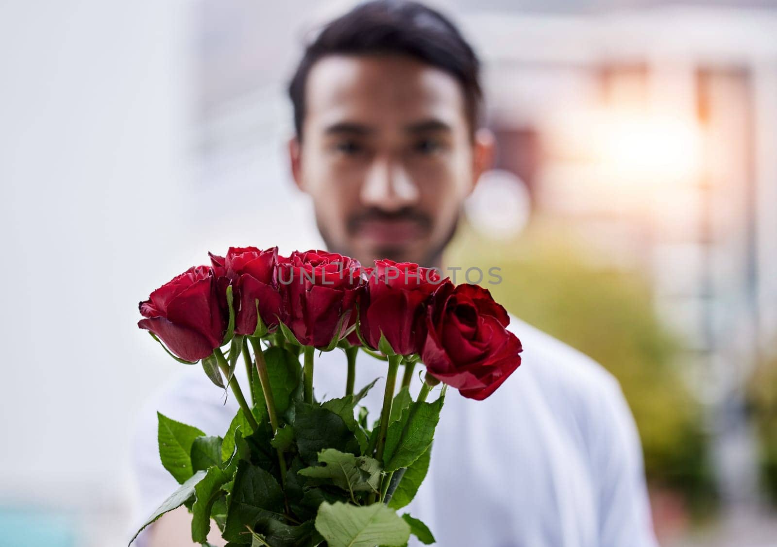 Love, giving and man with bouquet of roses for date, romance and hope for valentines day. Confession, romantic gift and person holding flowers outside, proposal or engagement on blurred background