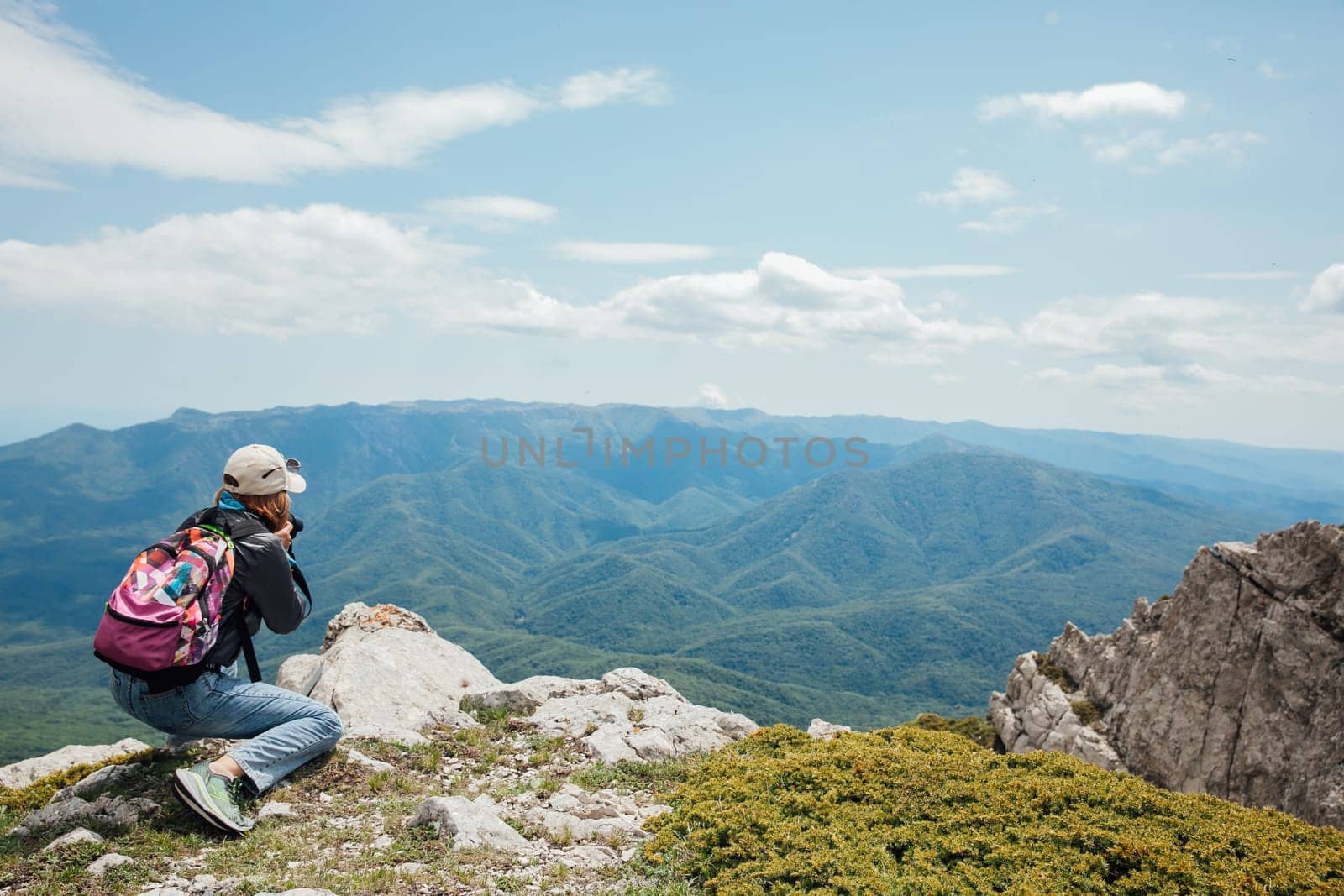 Woman on a hike photographing mountains, nature,