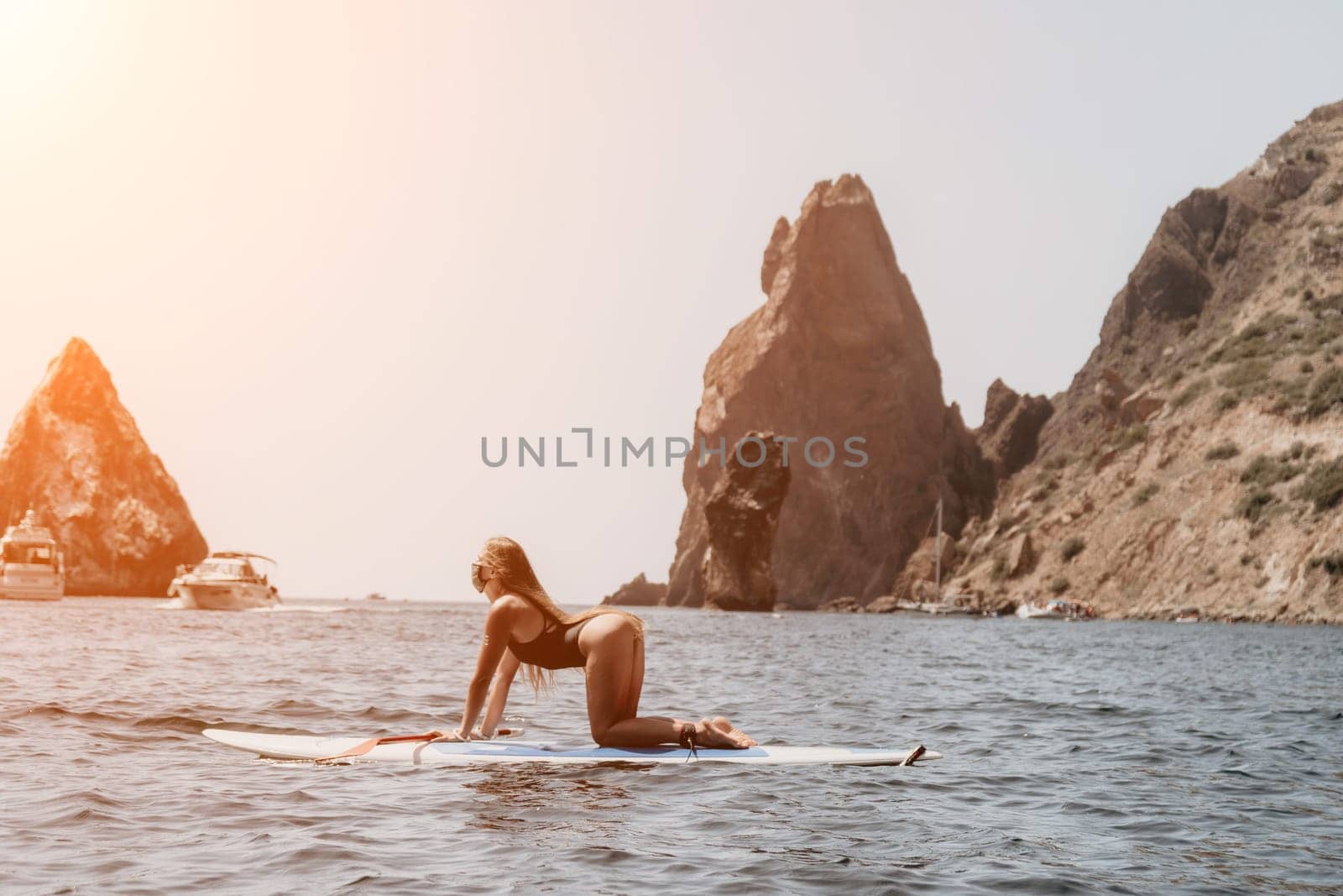 Woman sea sup. Close up portrait of happy young caucasian woman with long hair looking at camera and smiling. Cute woman portrait in bikini posing on sup board in the sea by panophotograph