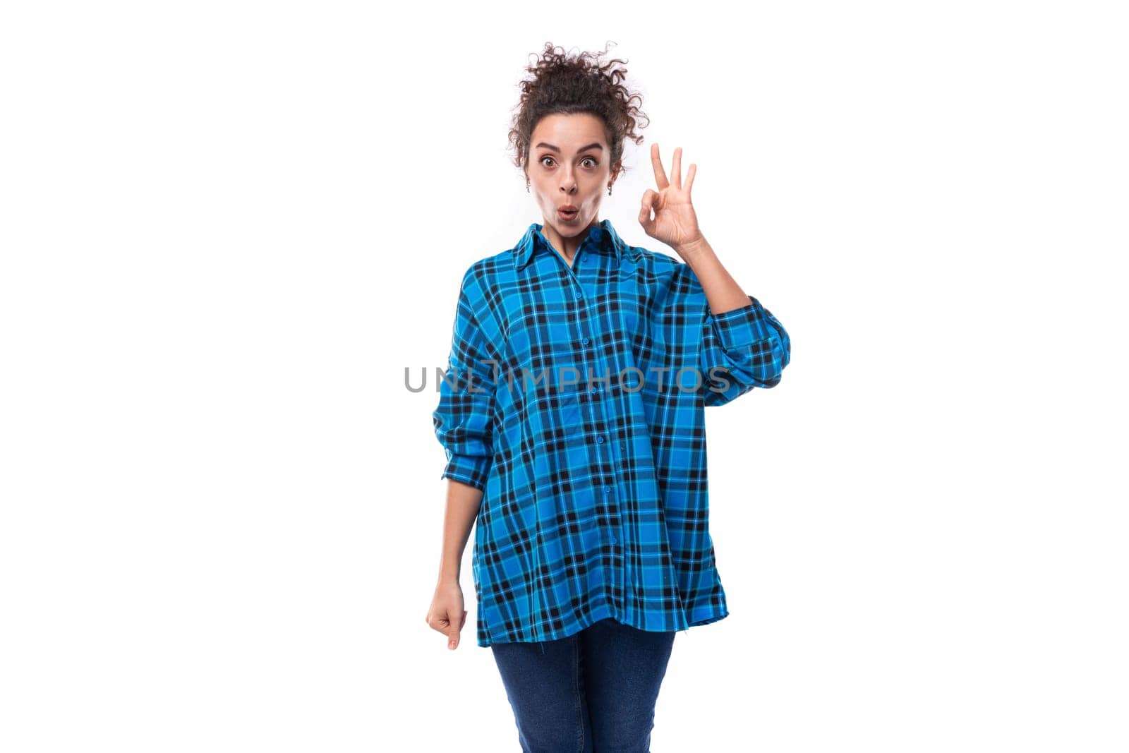 young smart curly brunette woman in a blue plaid shirt on a white background by TRMK