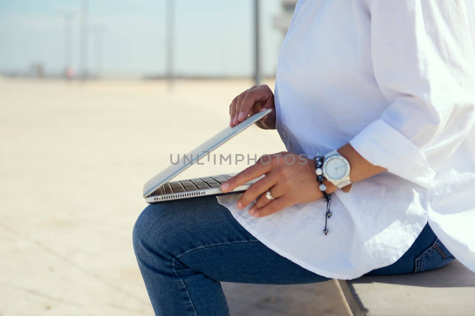 Details on female entrepreneur hands opening the laptop lid, ready to online working outdoors. Online business. Freelance occupation. People, career and wireless digital technologies