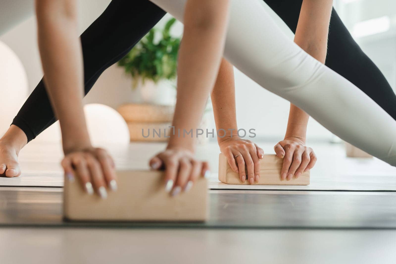 Close-up of female hands and feet practicing yoga using yoga blocks to support their body. Women's Health by Lobachad