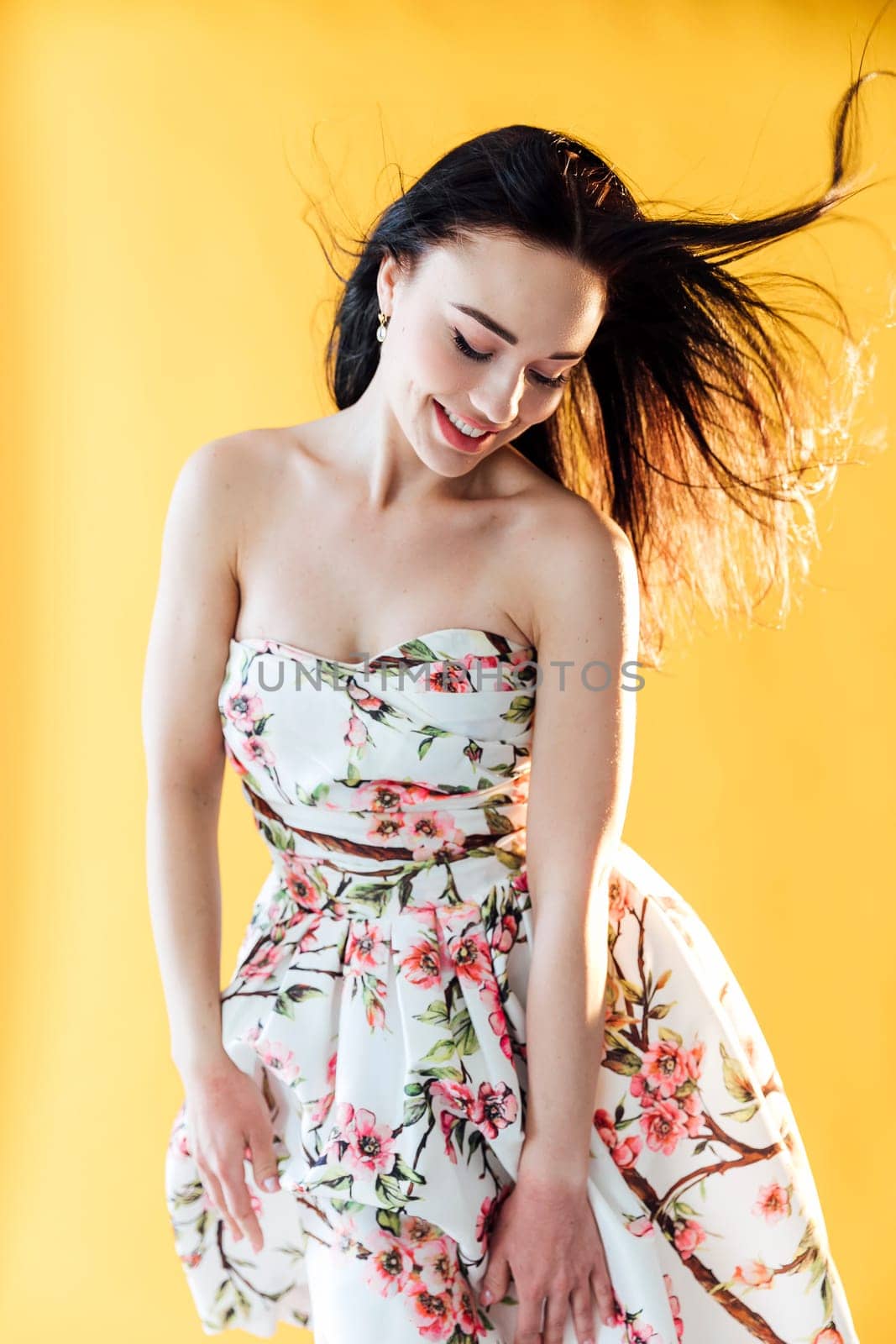 beautiful woman in floral dress posing in a bright room