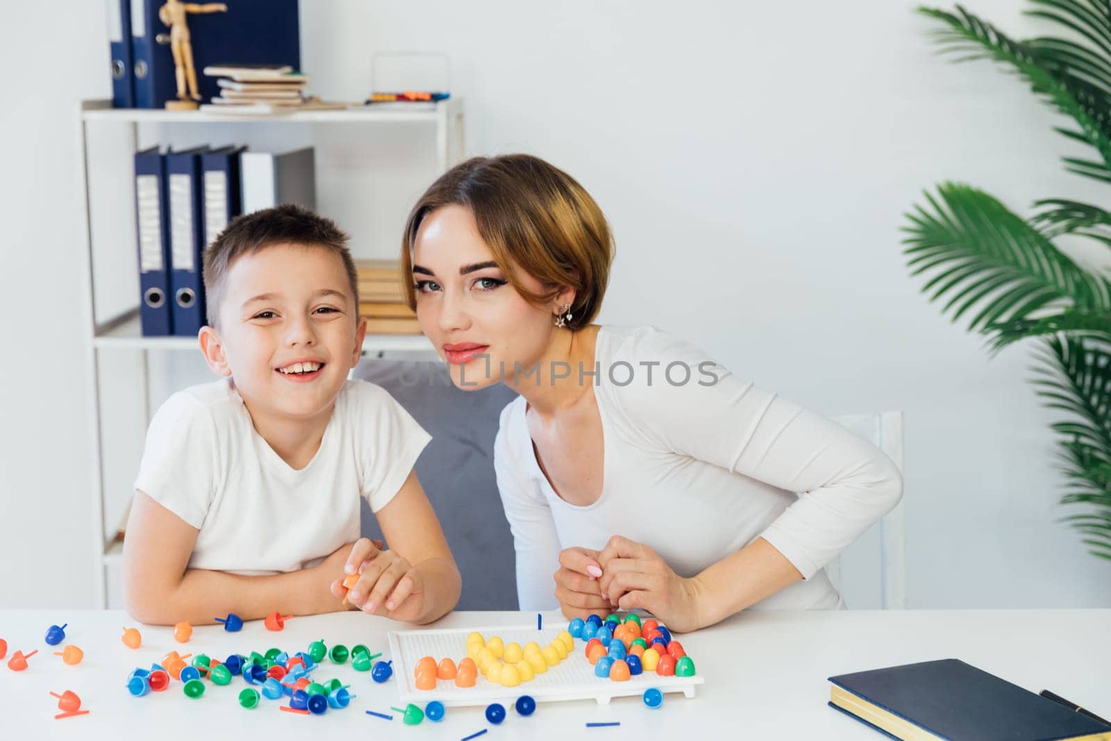 female psychologist develops boy fine motor skills development learning by Simakov