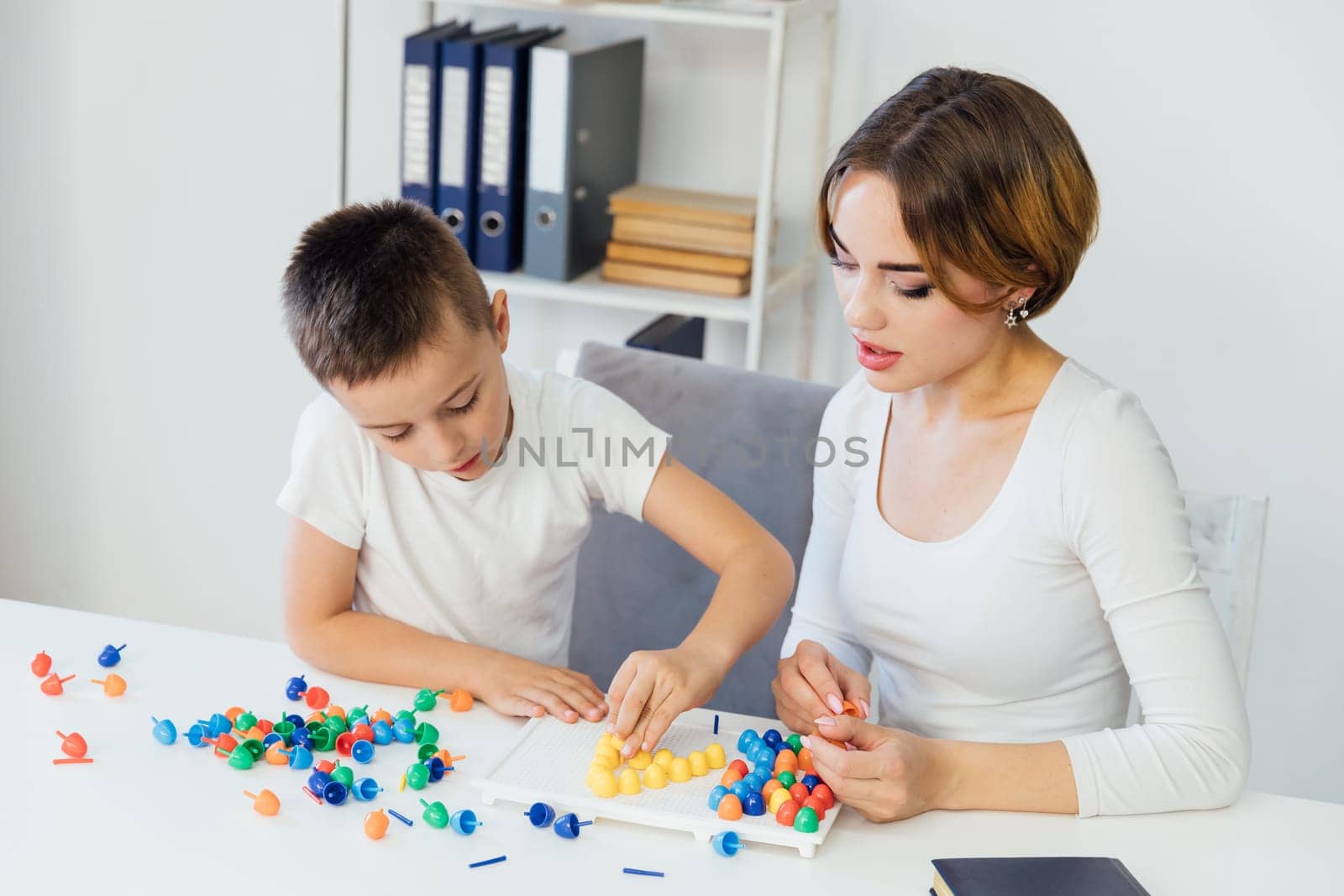 female psychologist develops boy fine motor skills development learning by Simakov