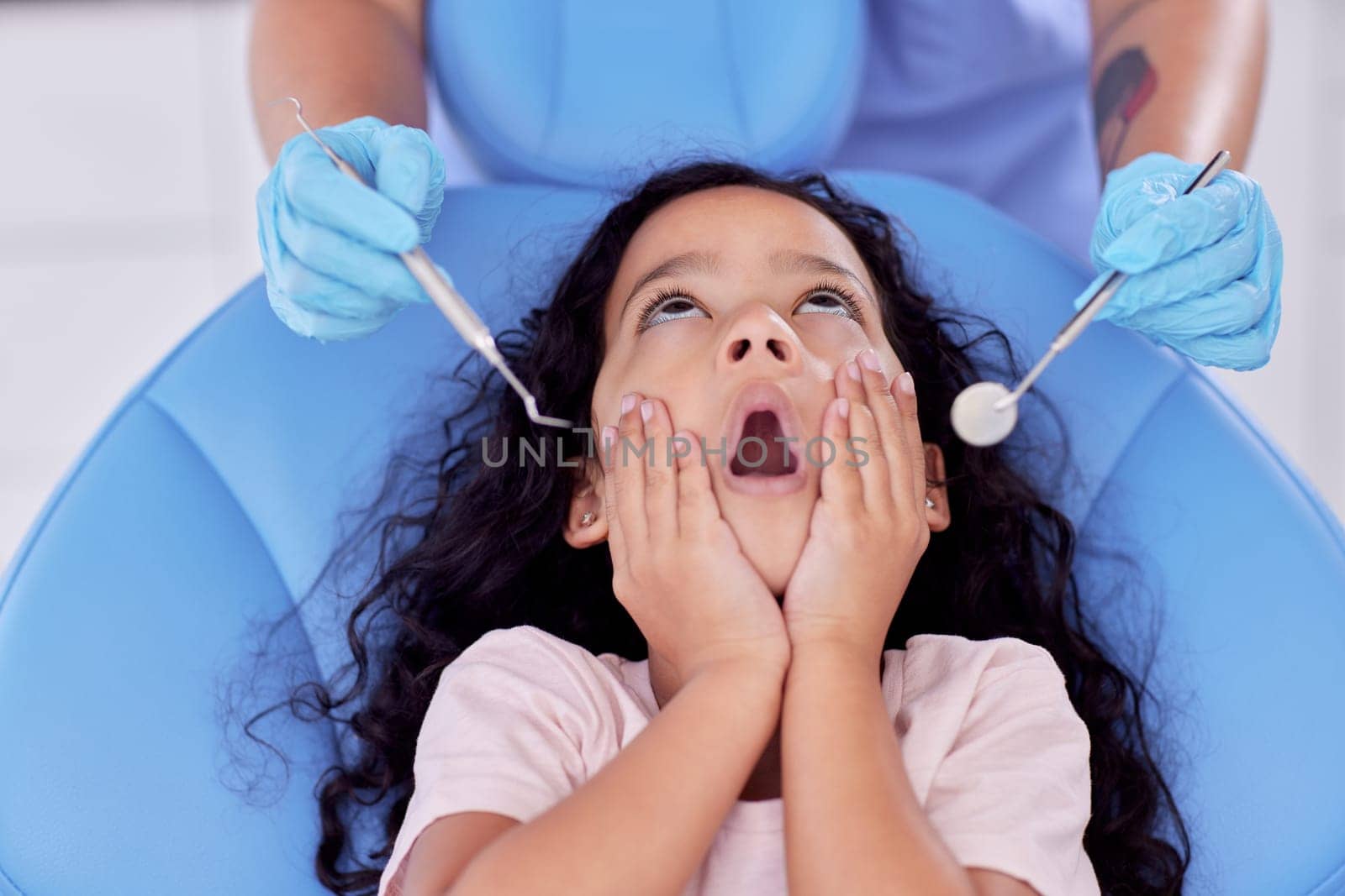 If a patient cannot clean his teeth, no dentist can. a little girl looking shocked at the dentist