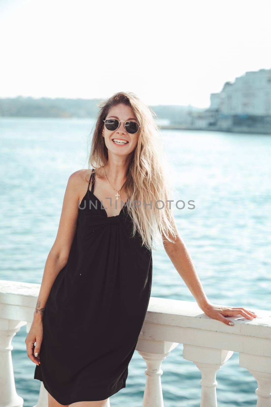 beautiful woman stands near the white railings on a walk travel vacation
