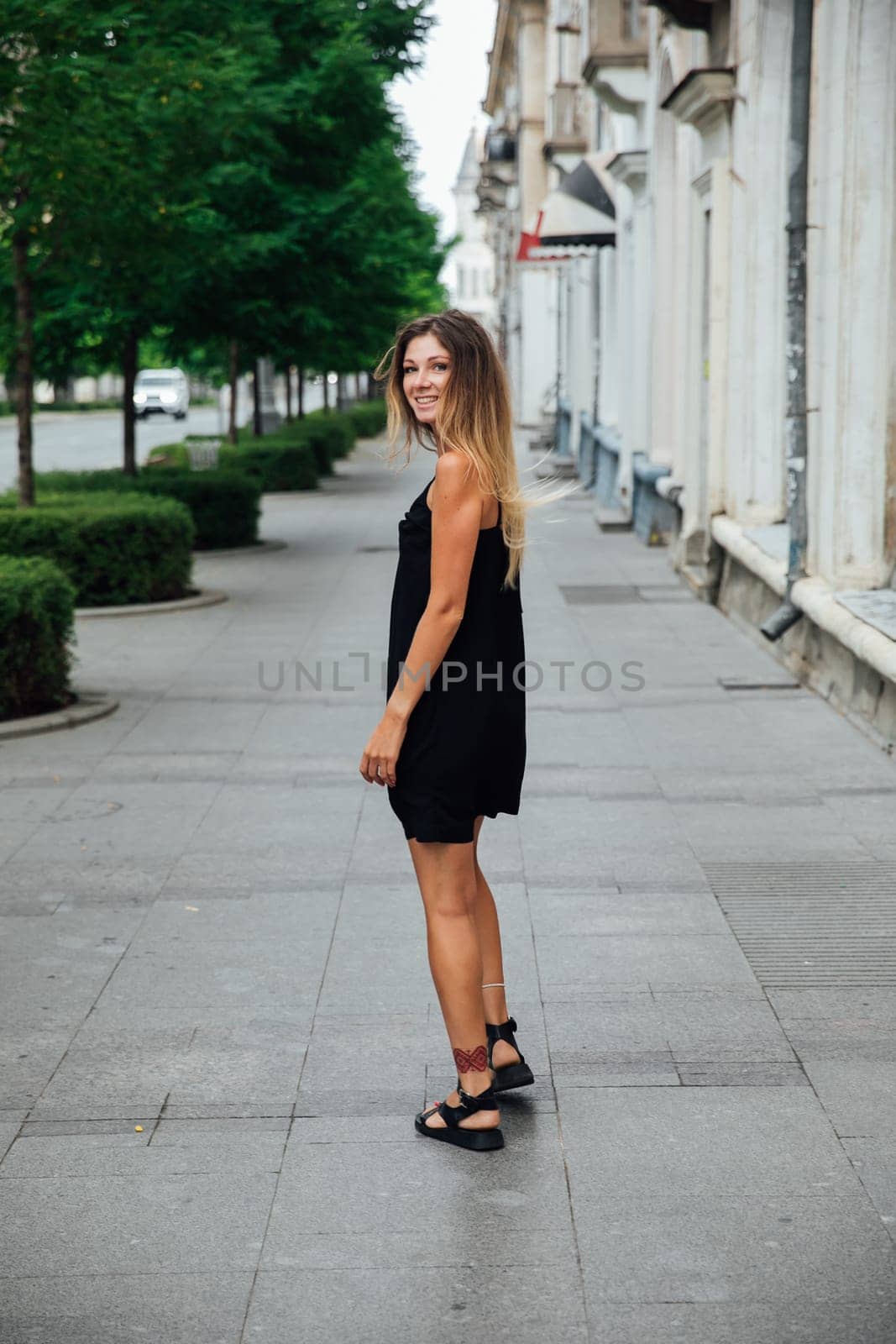 woman in black dress on the street walk travel vacation by Simakov