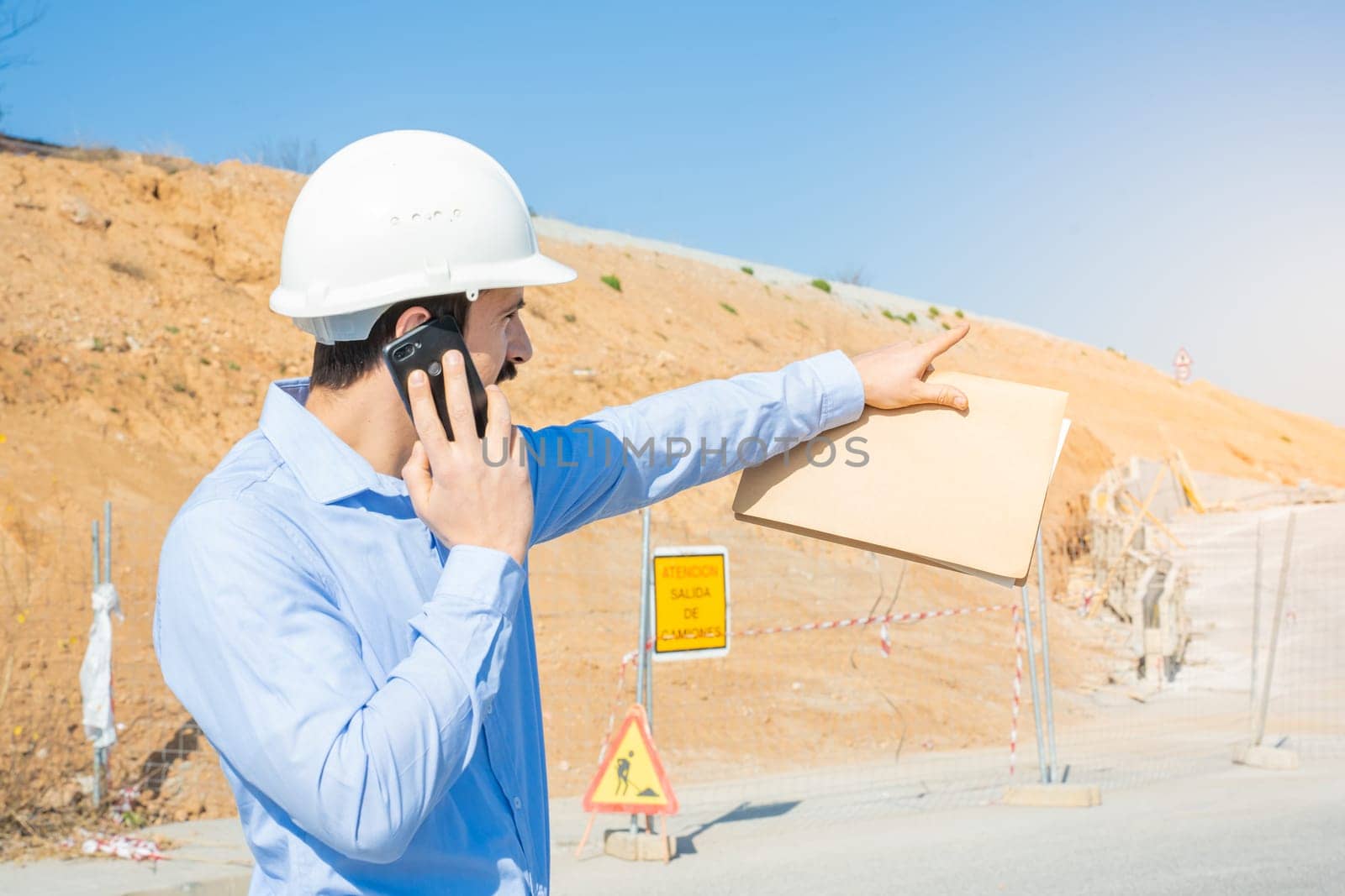 Construction man with white helmet working with phone. High quality photo