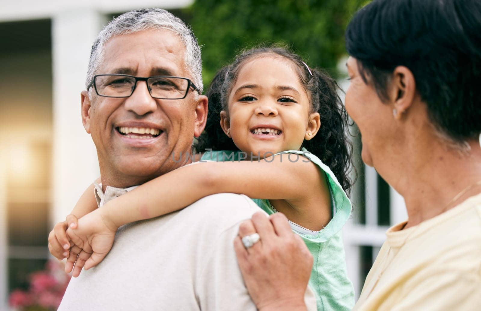 Grandparents, child and piggyback, happiness and hug with love, young girl with old man and woman outdoor. Relax, smile and trust, care and happy family, people on lawn of holiday home with fun.