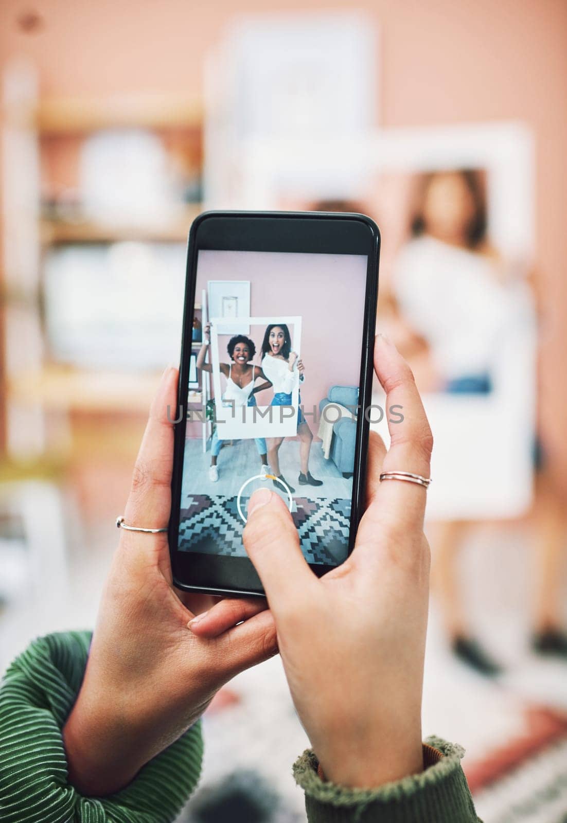 Lets start a trend. two young women posing with a social media prop while having their picture taking on a smartphone