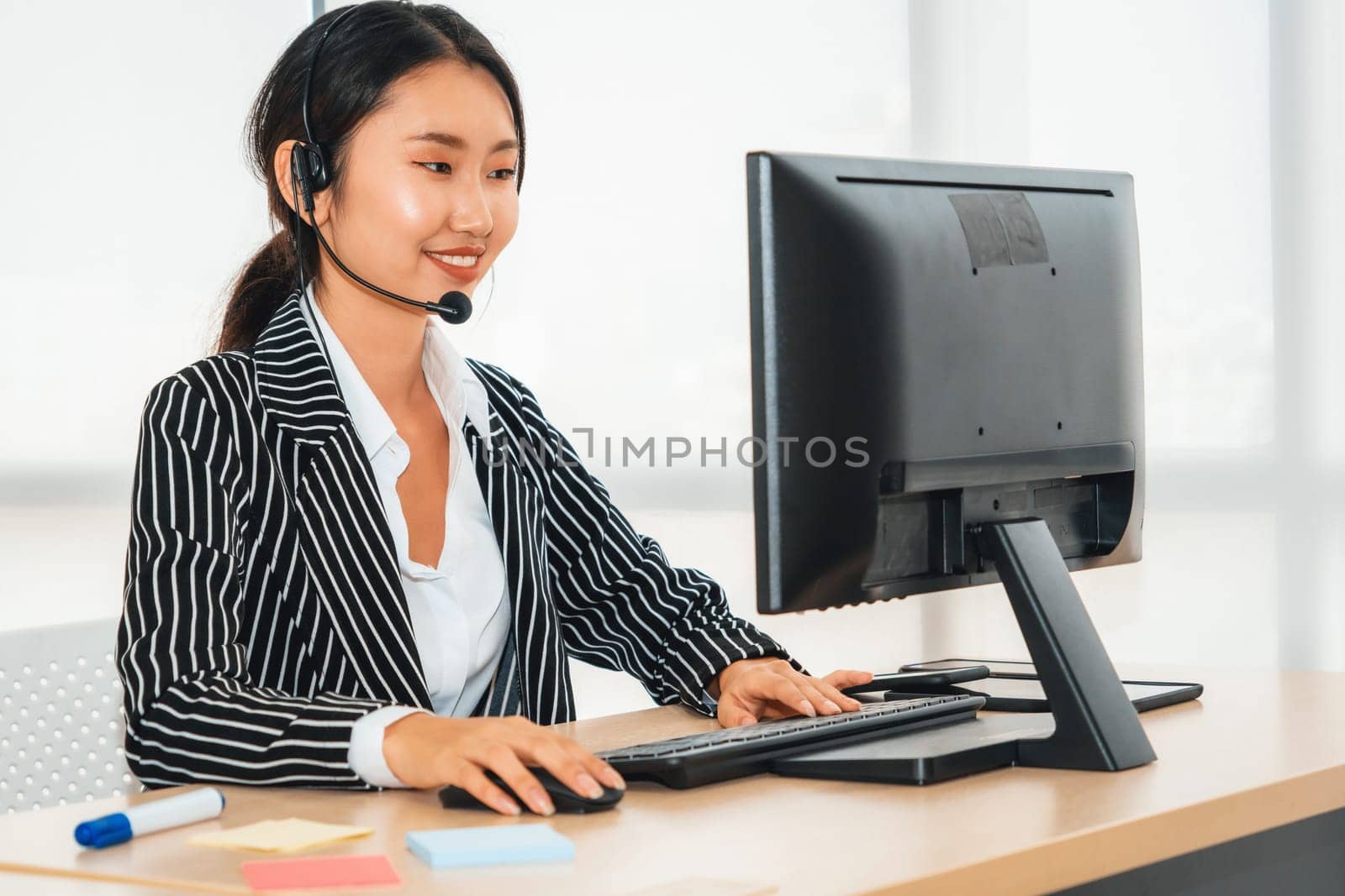 Business people wearing headset working in office to support remote customer or colleague. Call center, telemarketing, customer support agent provide service on telephone video conference call. Jivy