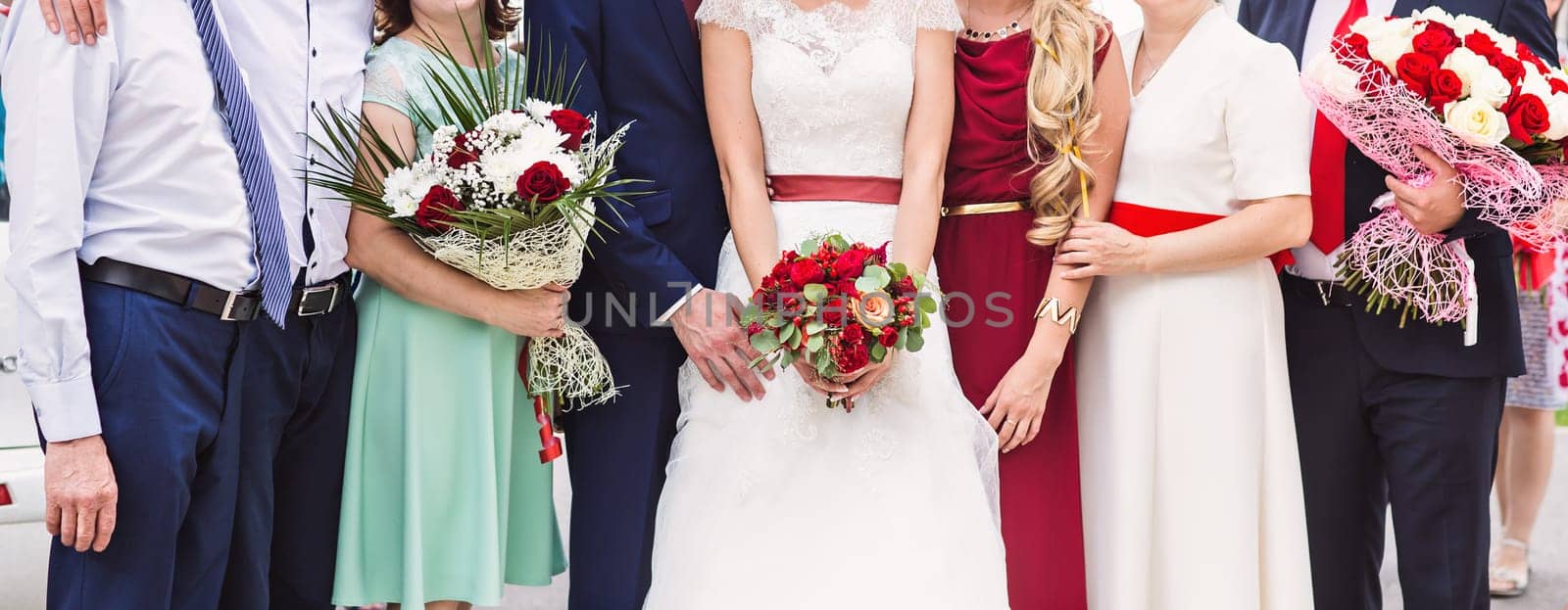 Bride, guests and bridesmaids at wedding ceremony outdoors.