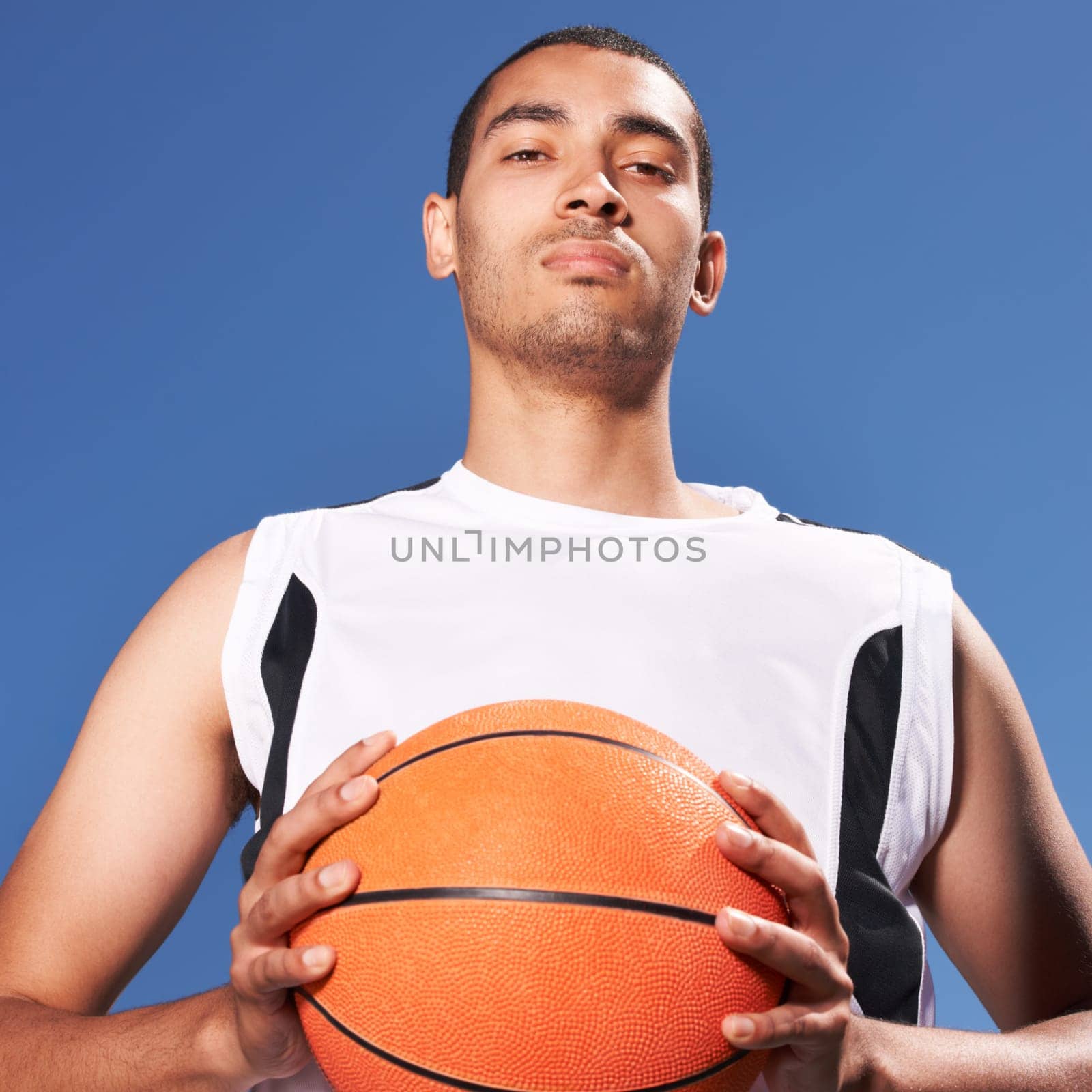 Confident, basketball player and outdoor portrait for sport, game and competition in summer with sky background. Serious, challenge and man with ball for exercise, goals or fitness from training.