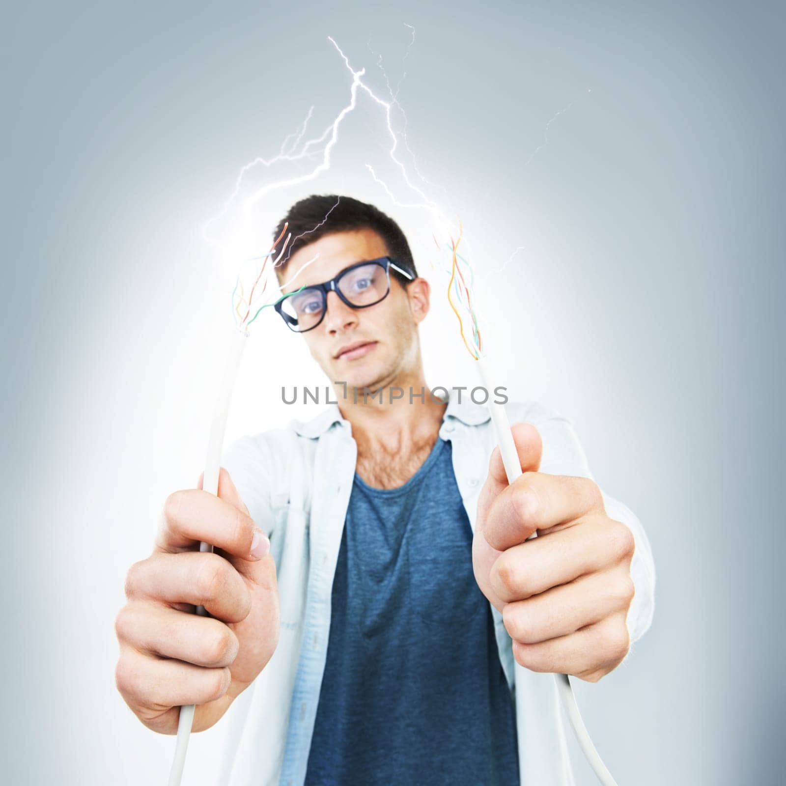 Man, glasses and wires for cable in studio for electricity, spark or danger mockup on gray background. Portrait, technician or electrician by career for fixing, glitch or 404 on internet, web or app.