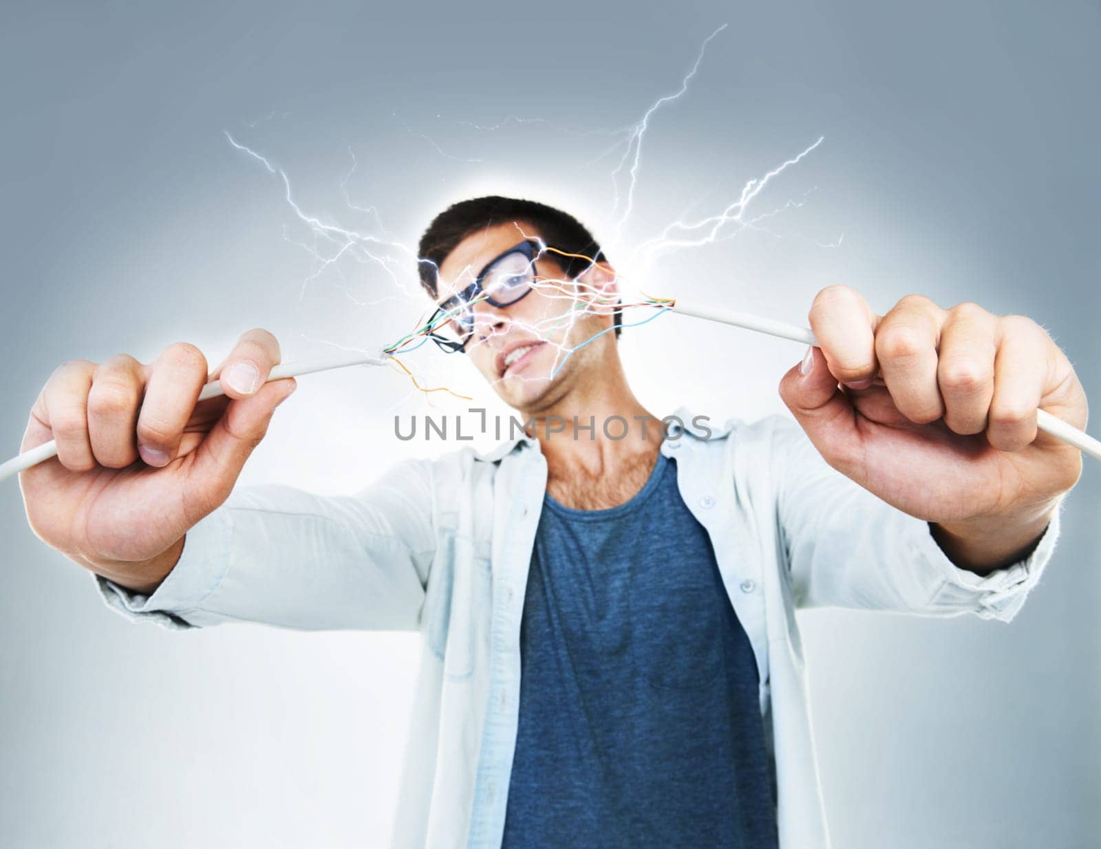 Man, holding and wire for power in studio for electric engineering mockup on gray background. Portrait, male model or technician for cable by fixing, repair and technology for glitch on web in Spain.