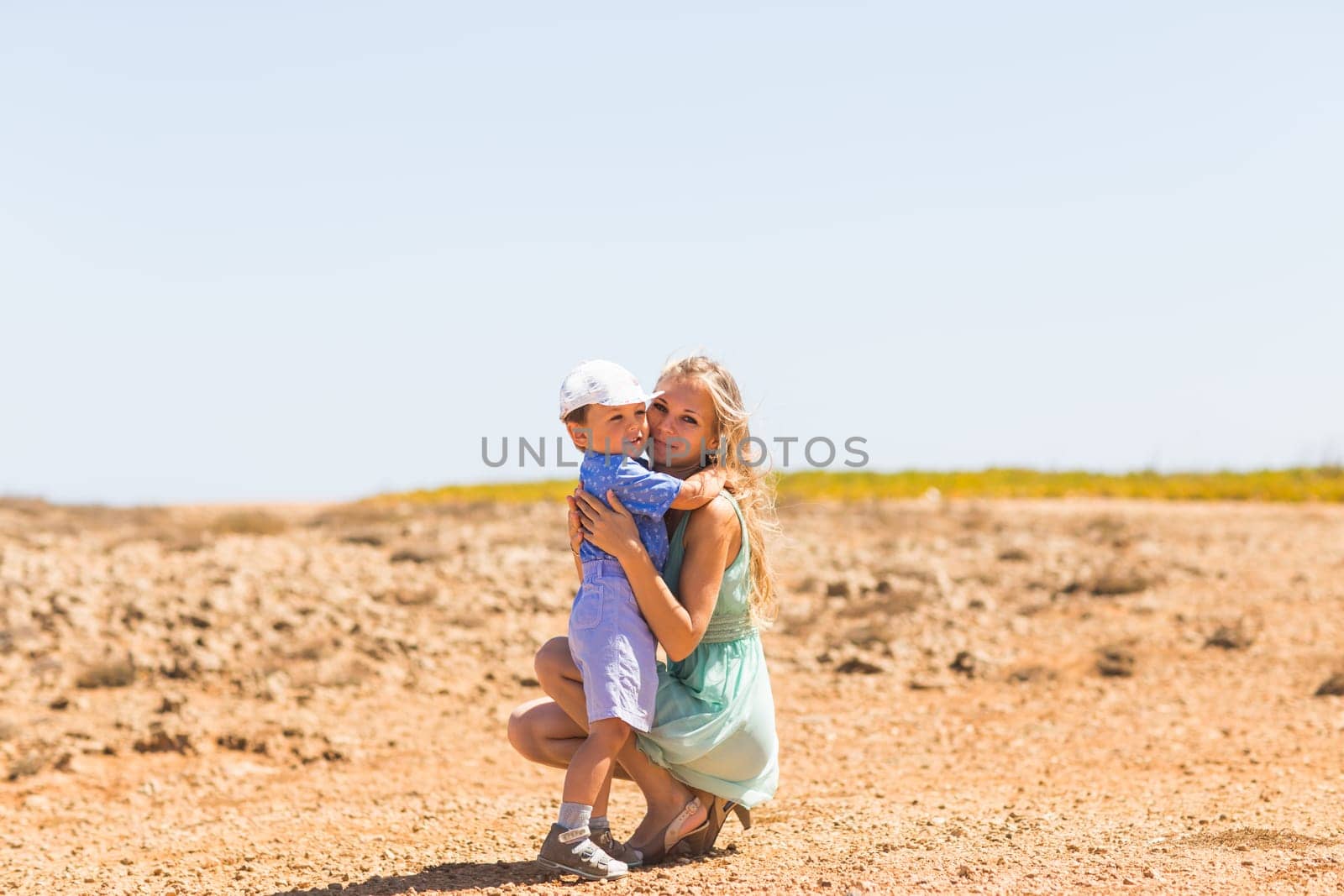 Loving mother and son hugging outdoors on beautiful summer day. by Satura86