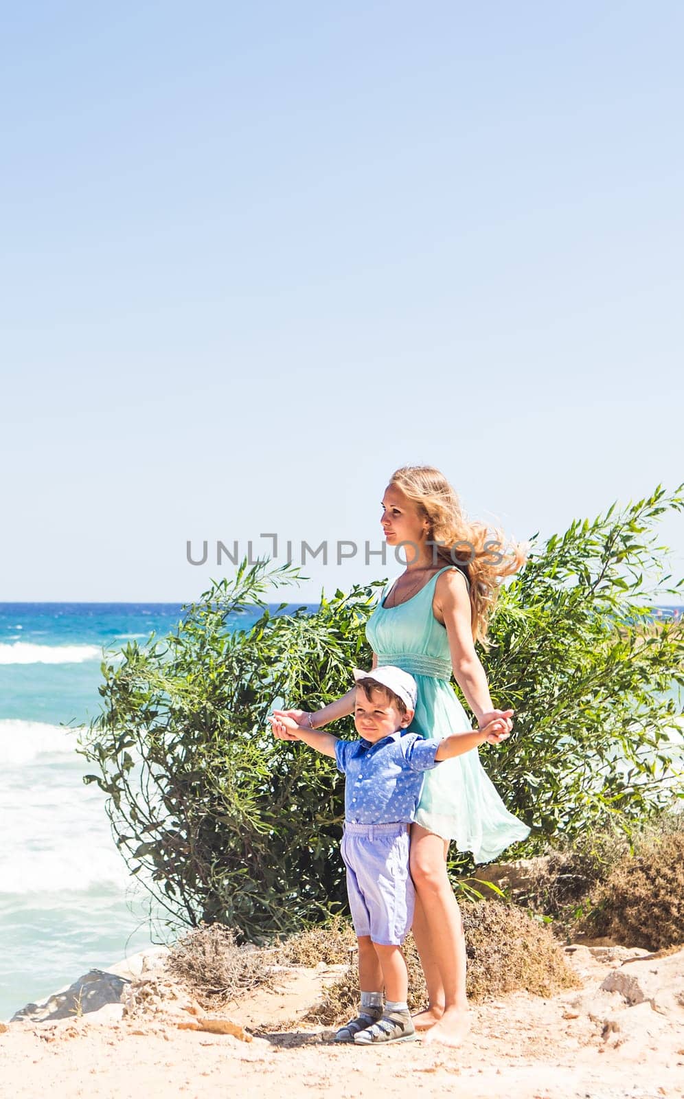 Happy mother with child son having fun outdoors in summer day.