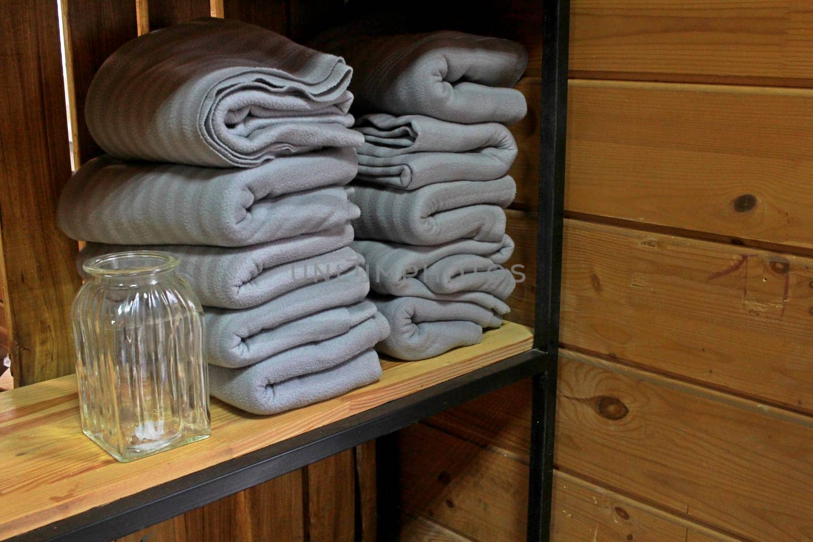 Photo gray blankets folded and a glass jar. by electrovenik