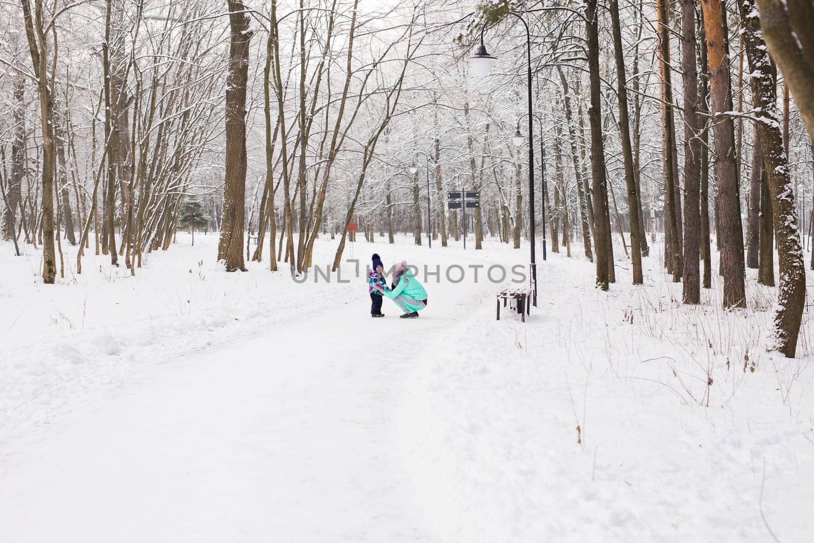 happy mother and baby in winter park. family outdoors. cheerful mommy with her child.
