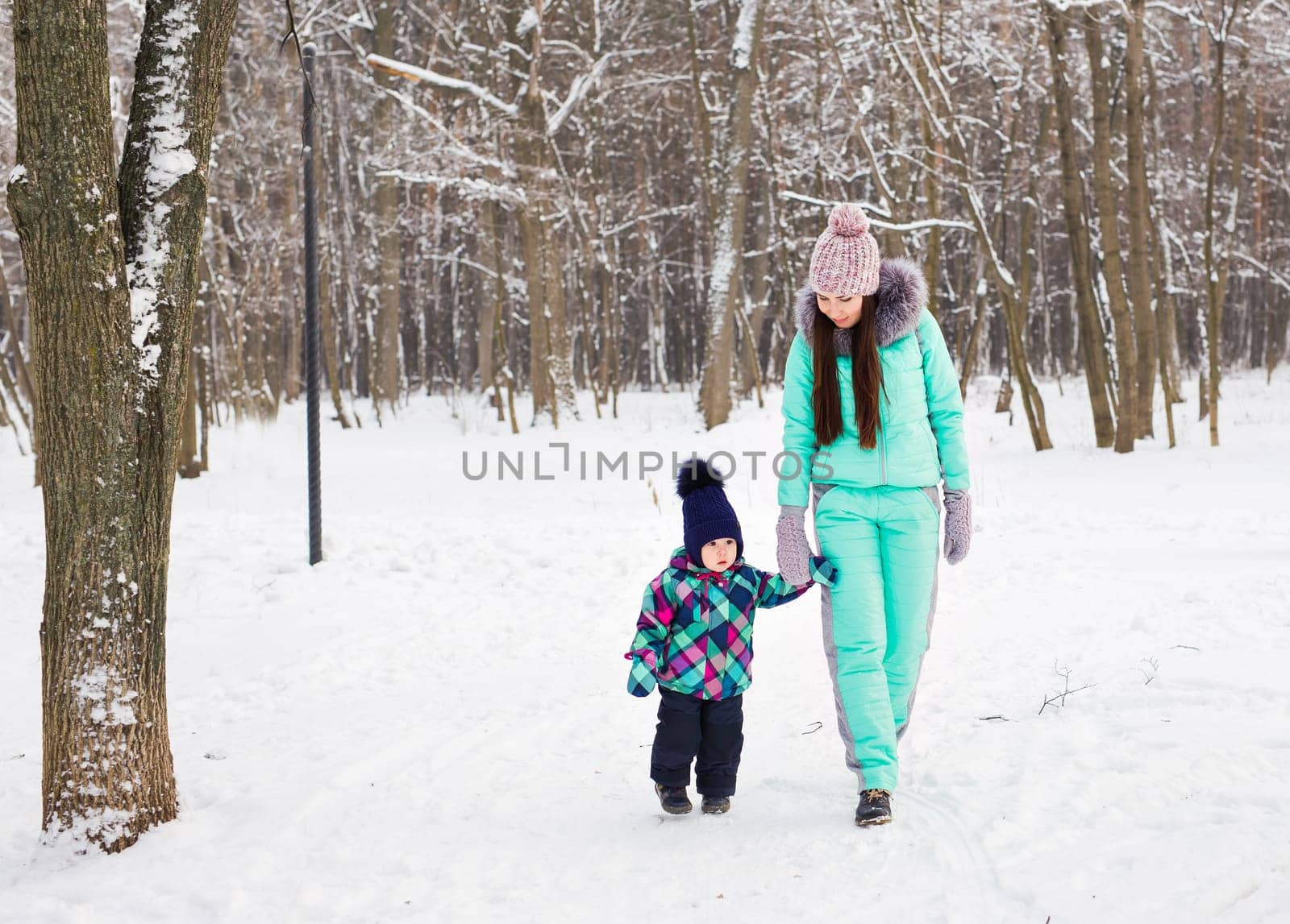 Little girl and her mom having fun on a winter day.