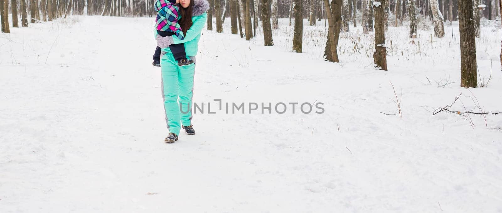 happy mother and baby in winter park. family outdoors. cheerful mommy with her child.