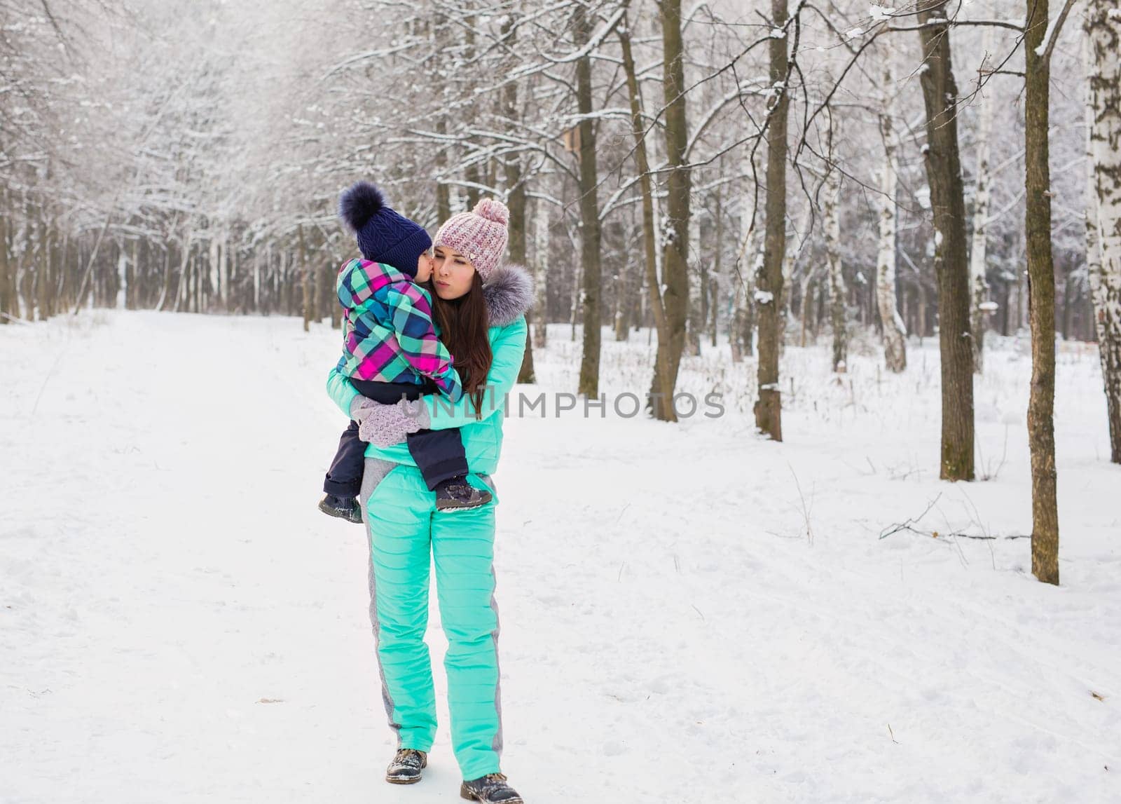 happy family mother and baby girl daughter playing and laughing in winter outdoors in the snow. by Satura86