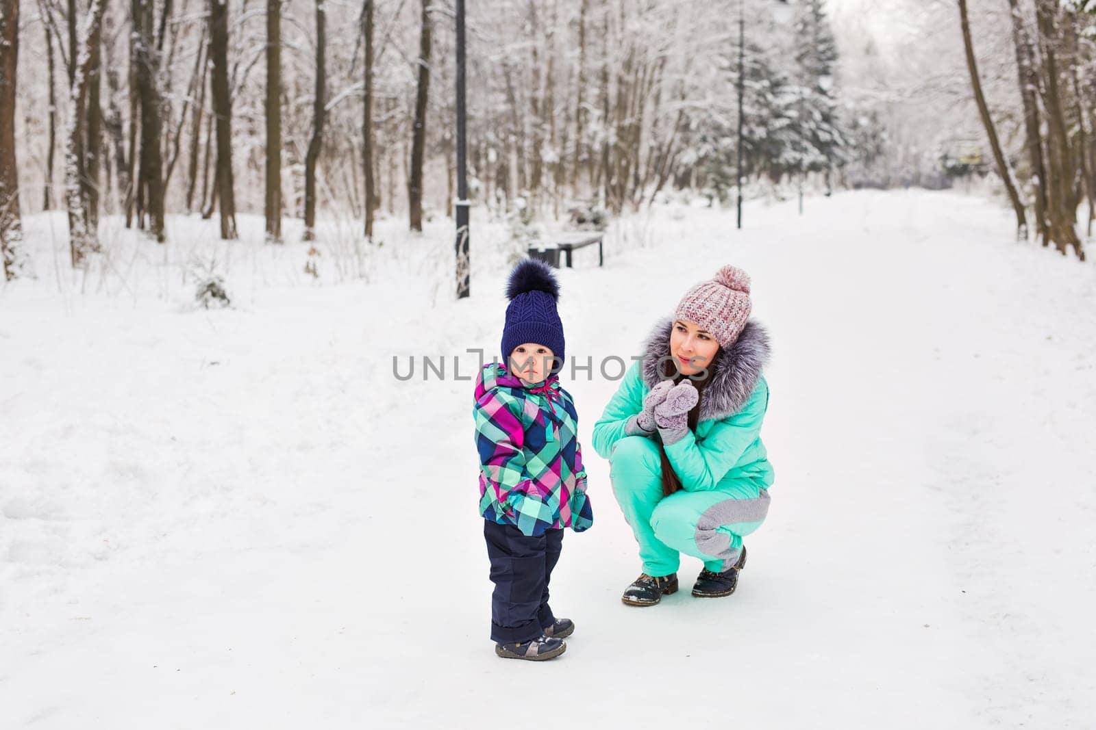 Portrait of happy mother and baby in winter park