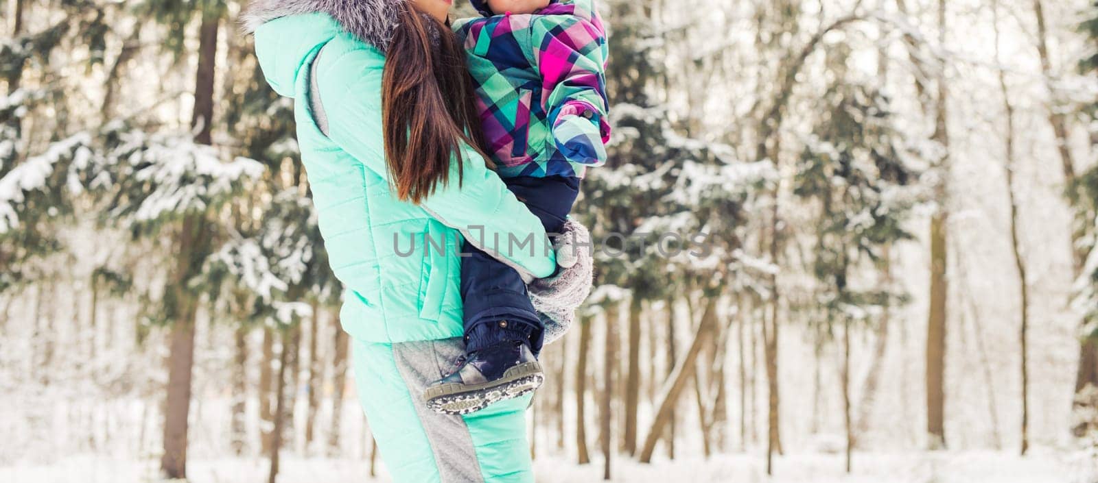 happy mother and baby in winter park. family outdoors. cheerful mommy with her child by Satura86