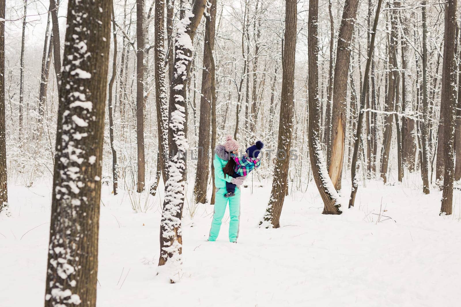 Portrait of happy mother and baby in winter park