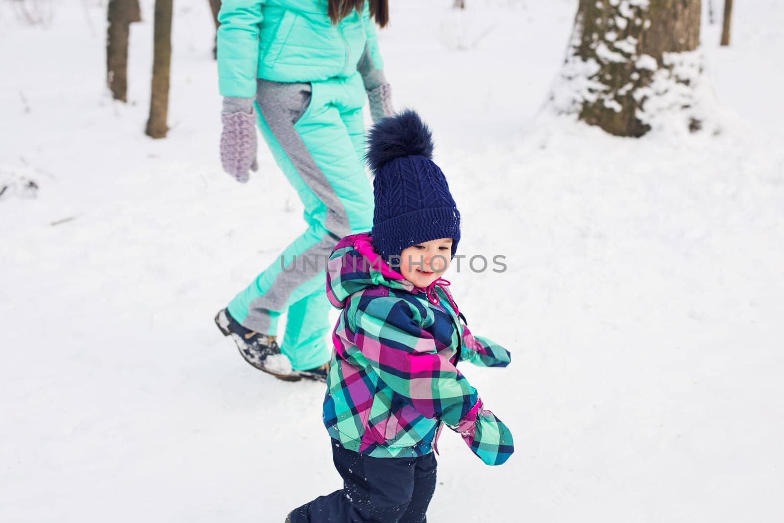 Little girl and her mom having fun on a winter day.