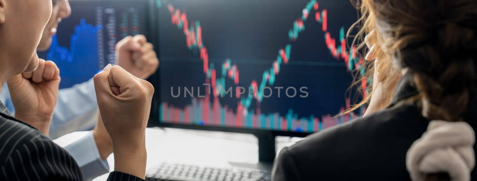 Happy successful business people celebrate while look at increasing stock market chart on black background displayed on computer. Smart investor cheering their success investment. Burgeoning.