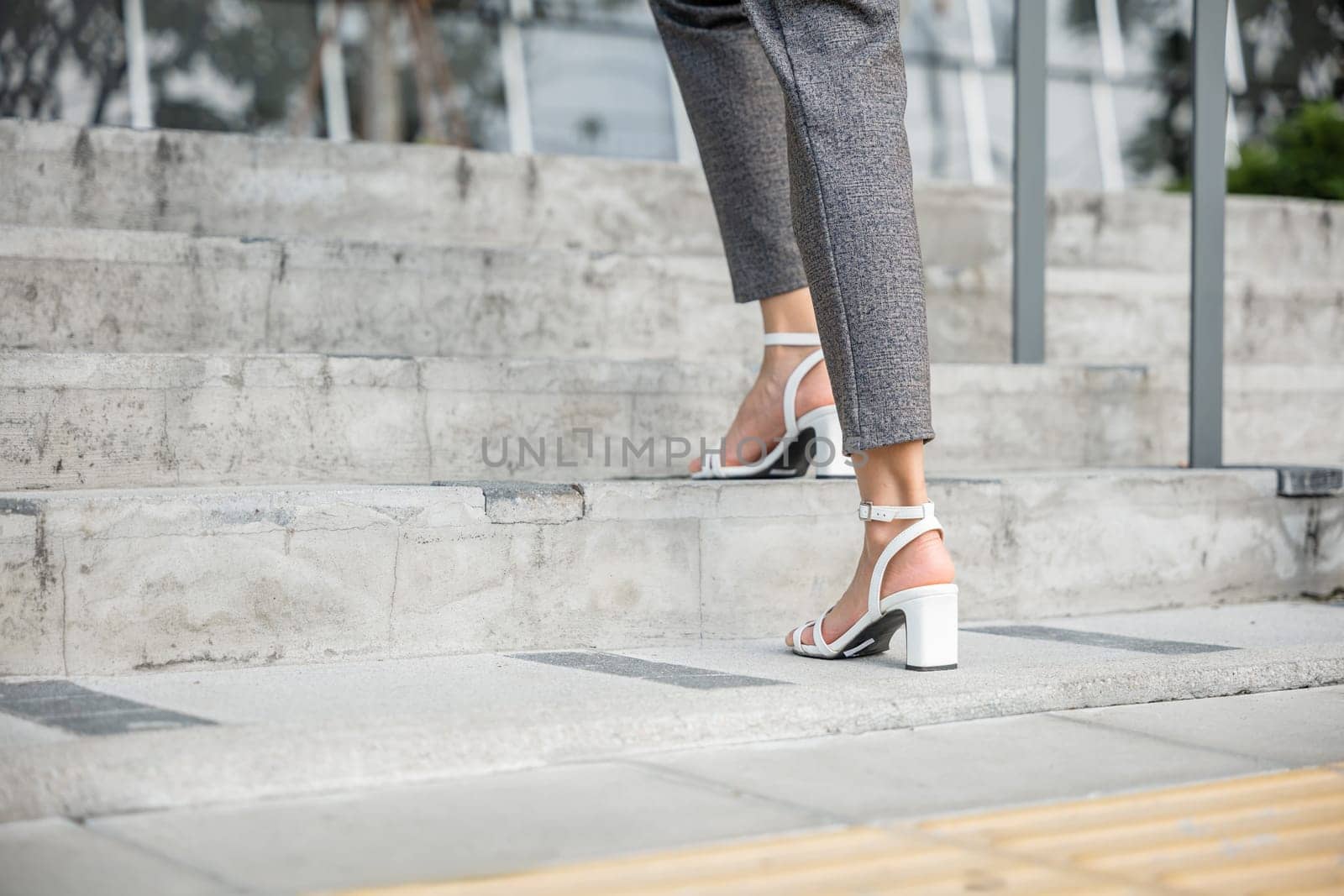 During the morning rush to the office businesswoman legs in motion are focused on climbing the stairs. This closeup captures the essence of progress, ambition, and the dedication of a modern manager. by Sorapop