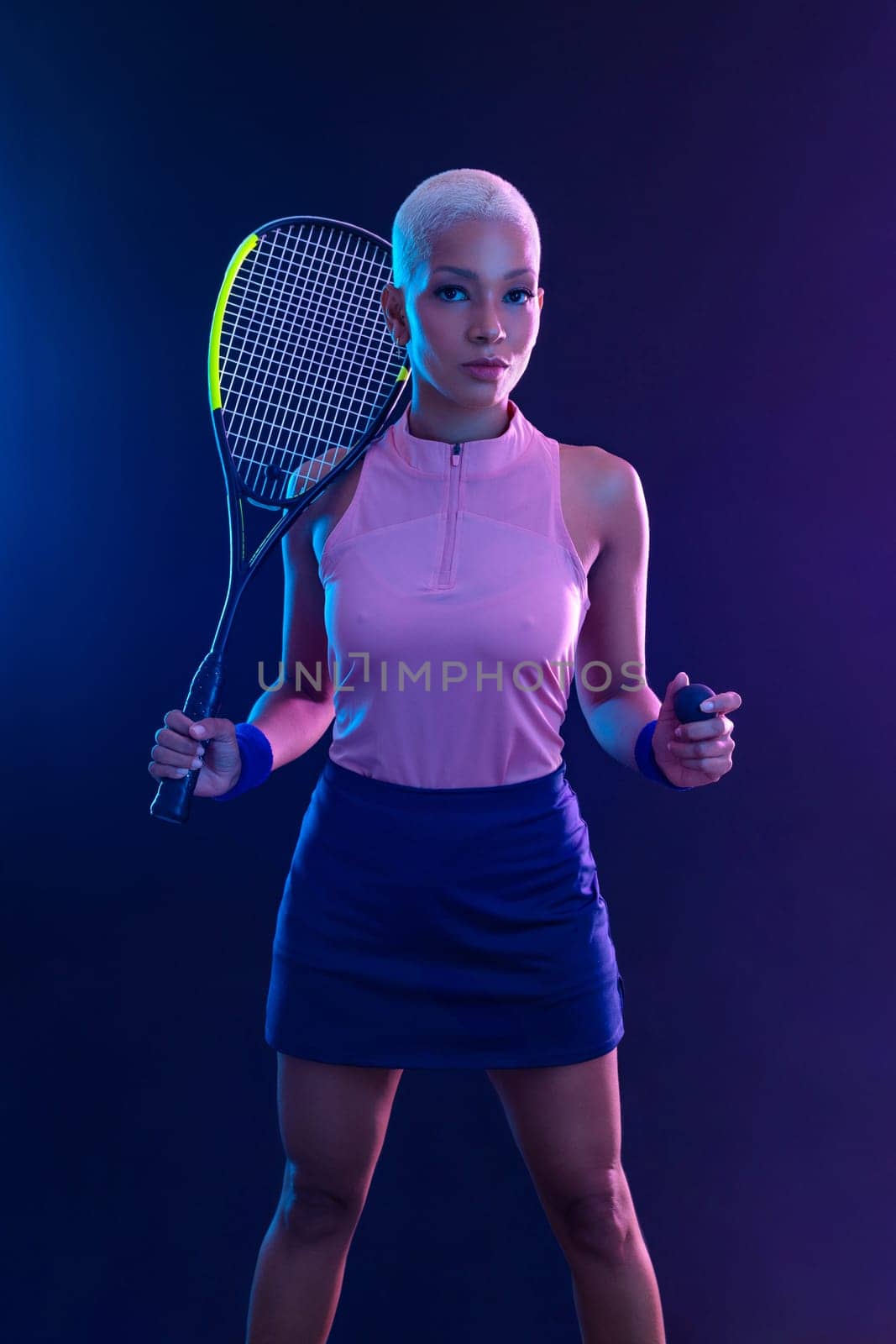 Squash player on a squash court with racket. White sportswear. Beautiful girl teenager and athlete with racket on court. Sport concept. by MikeOrlov